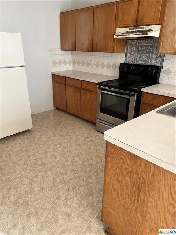 Natural wood cabinetry pairs with neutral tiled b