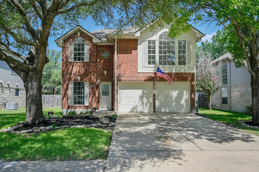 Mature trees shade a classic brick facade with a 