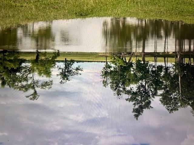 Mature trees frame a quiet pond on this expansive