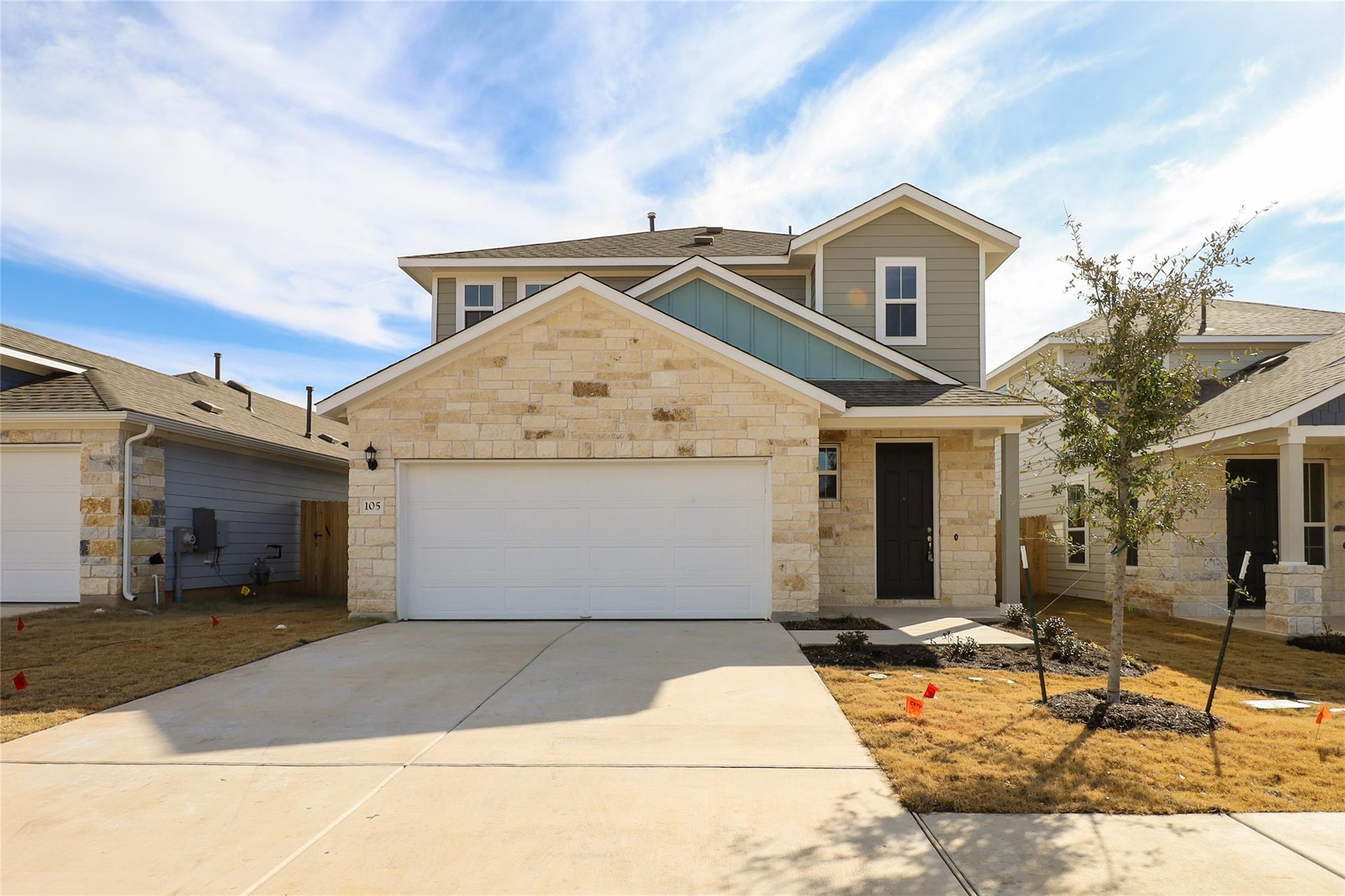 Textured stone siding and classic gables create a