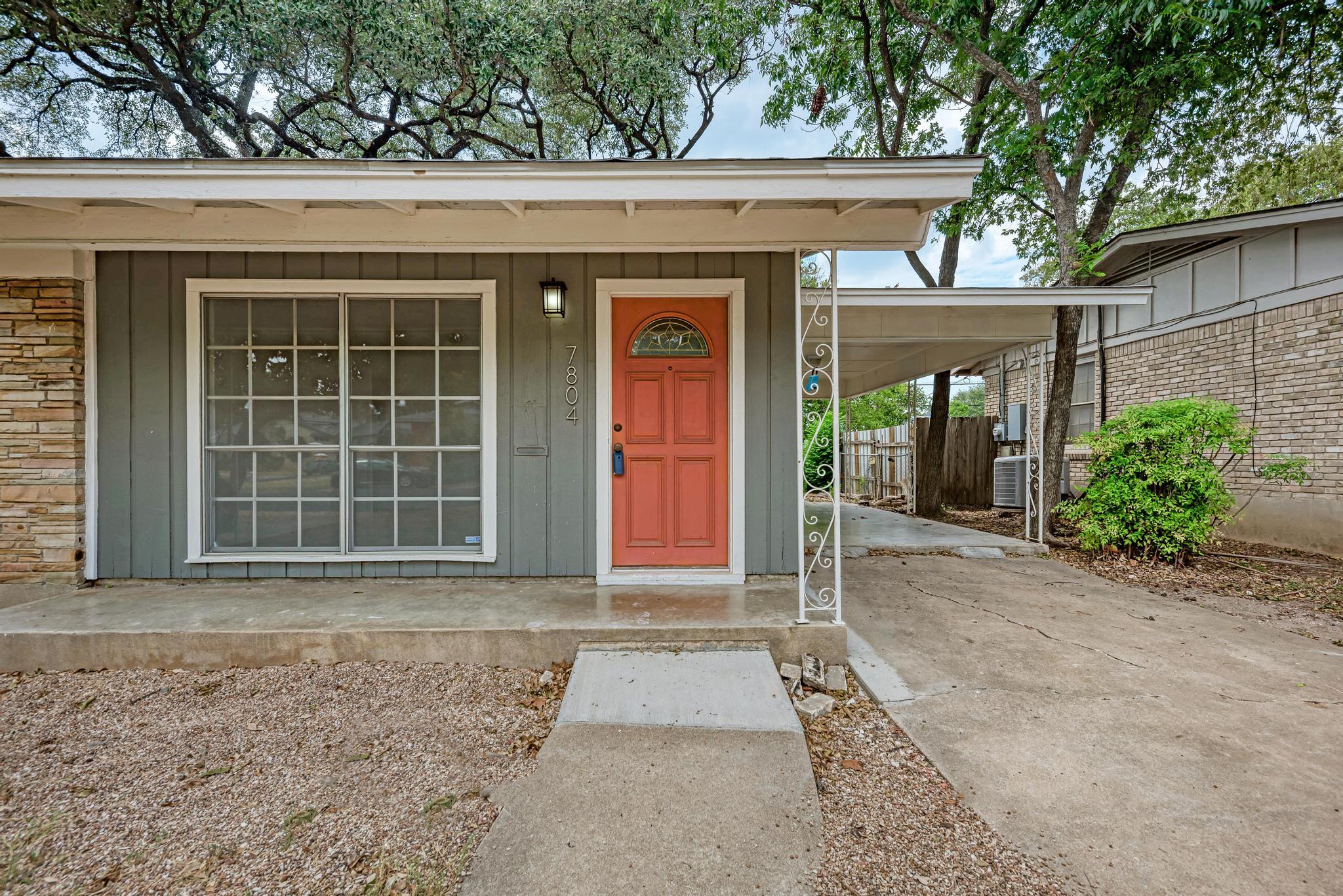 Mature trees shade a welcoming front porch, carpo