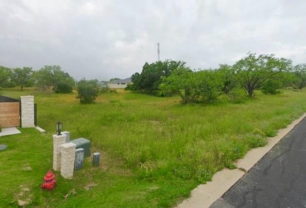 Mature trees frame a grassy building site ready f
