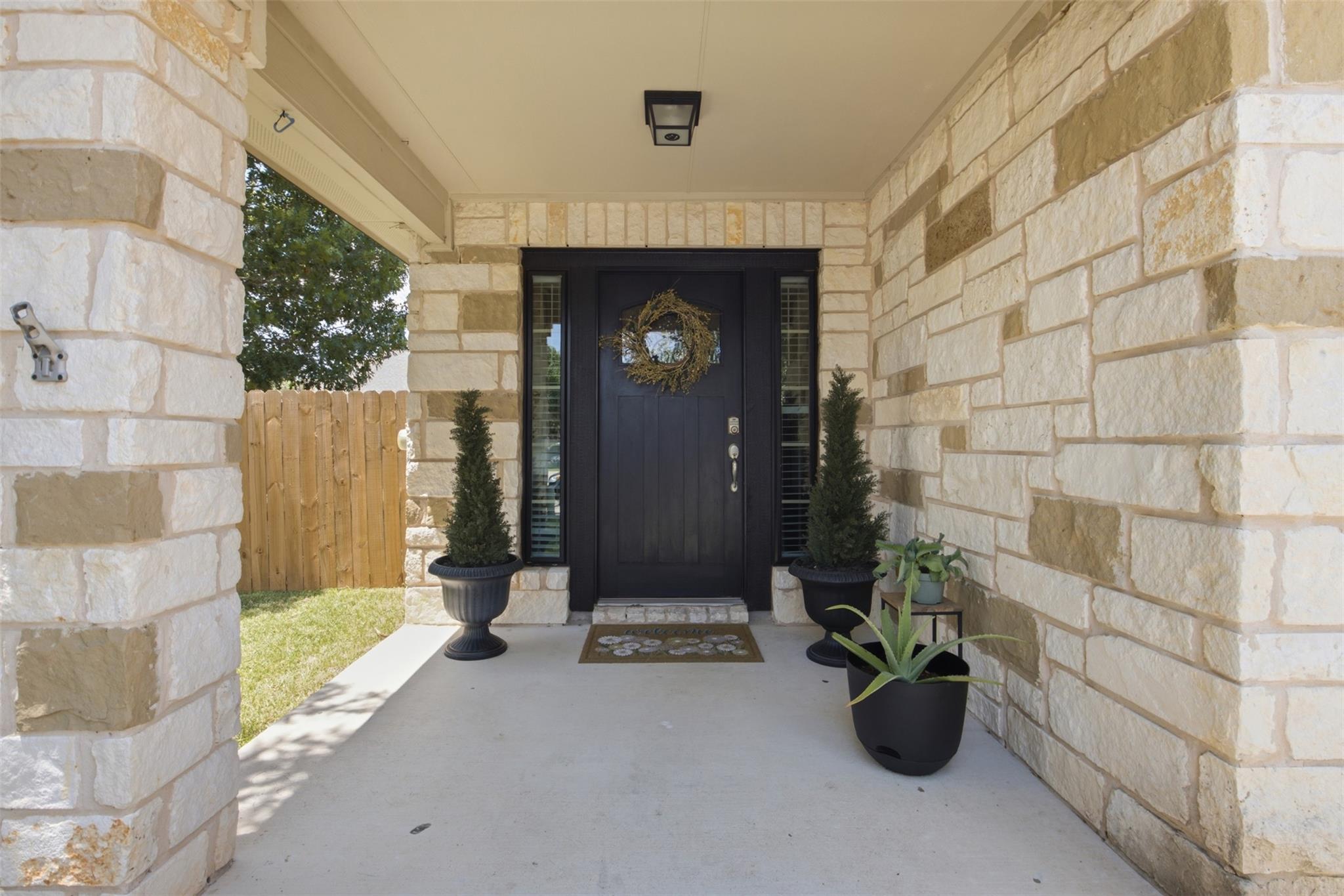 Natural stone columns frame a covered entryway fe