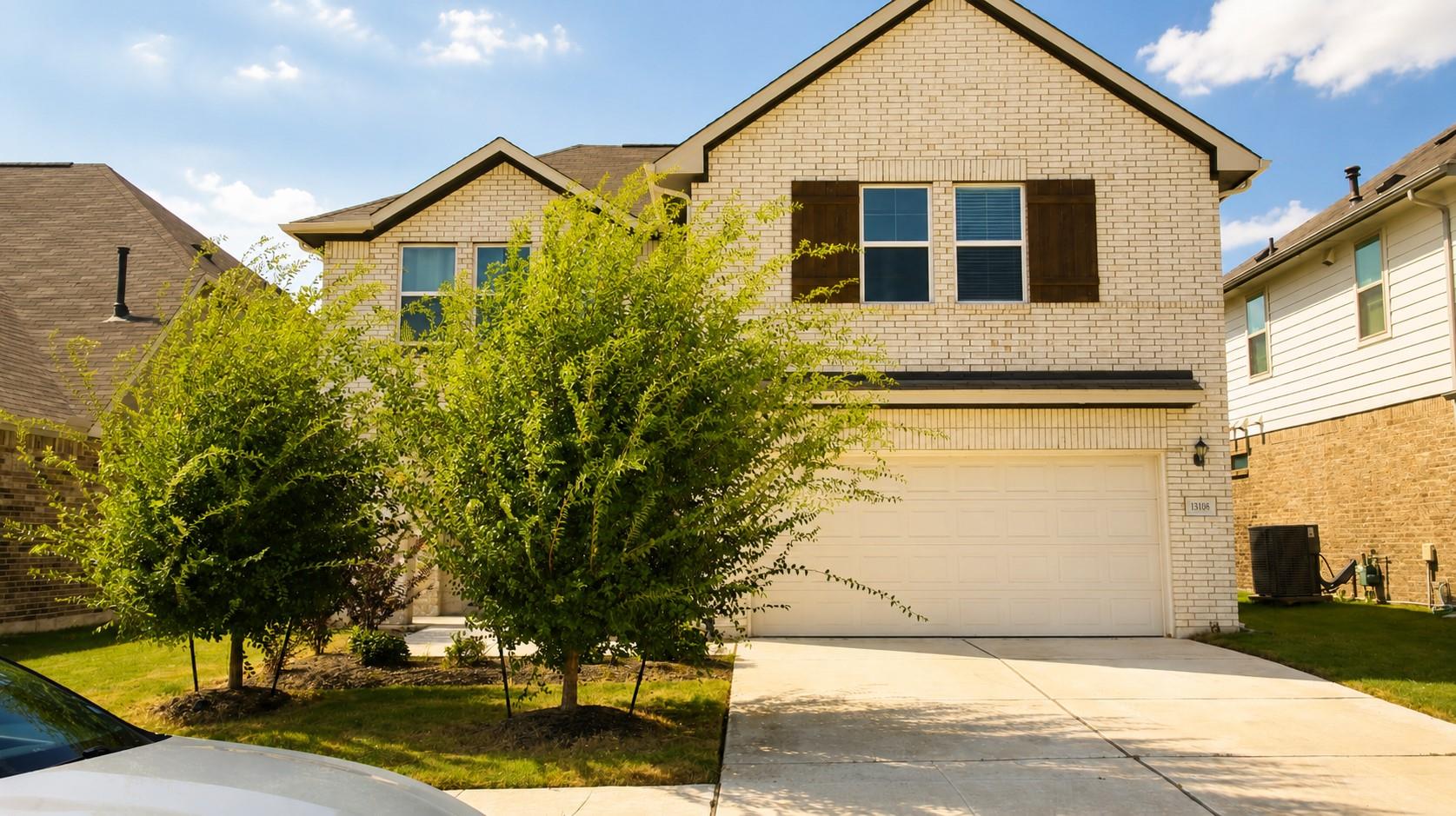 A classic brick exterior stands behind neat lands