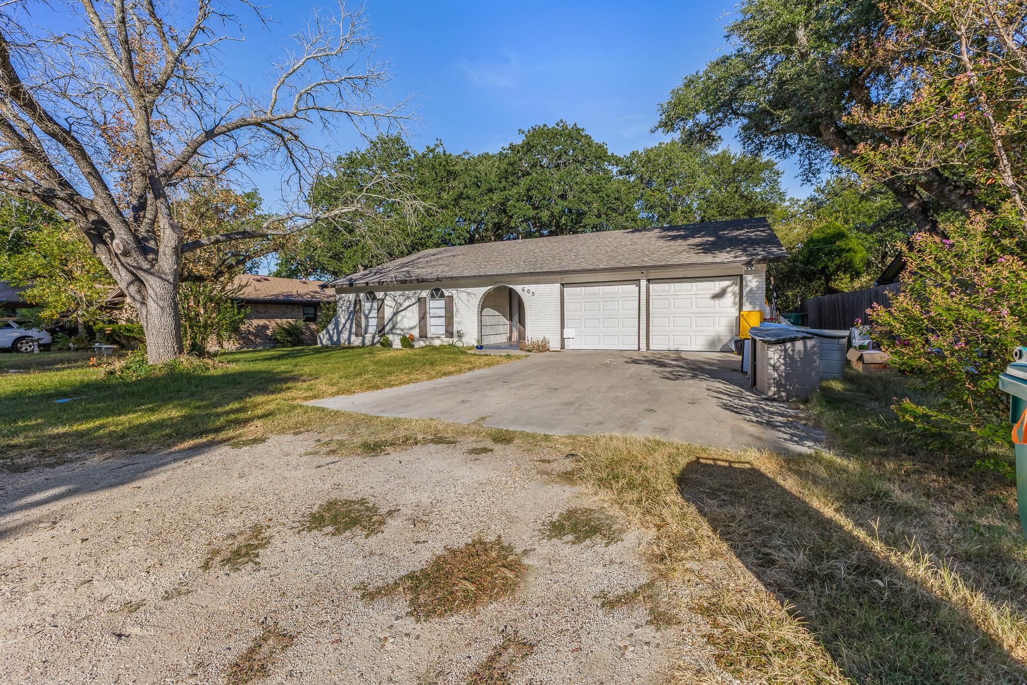 Mature trees frame a classic single-story exterio