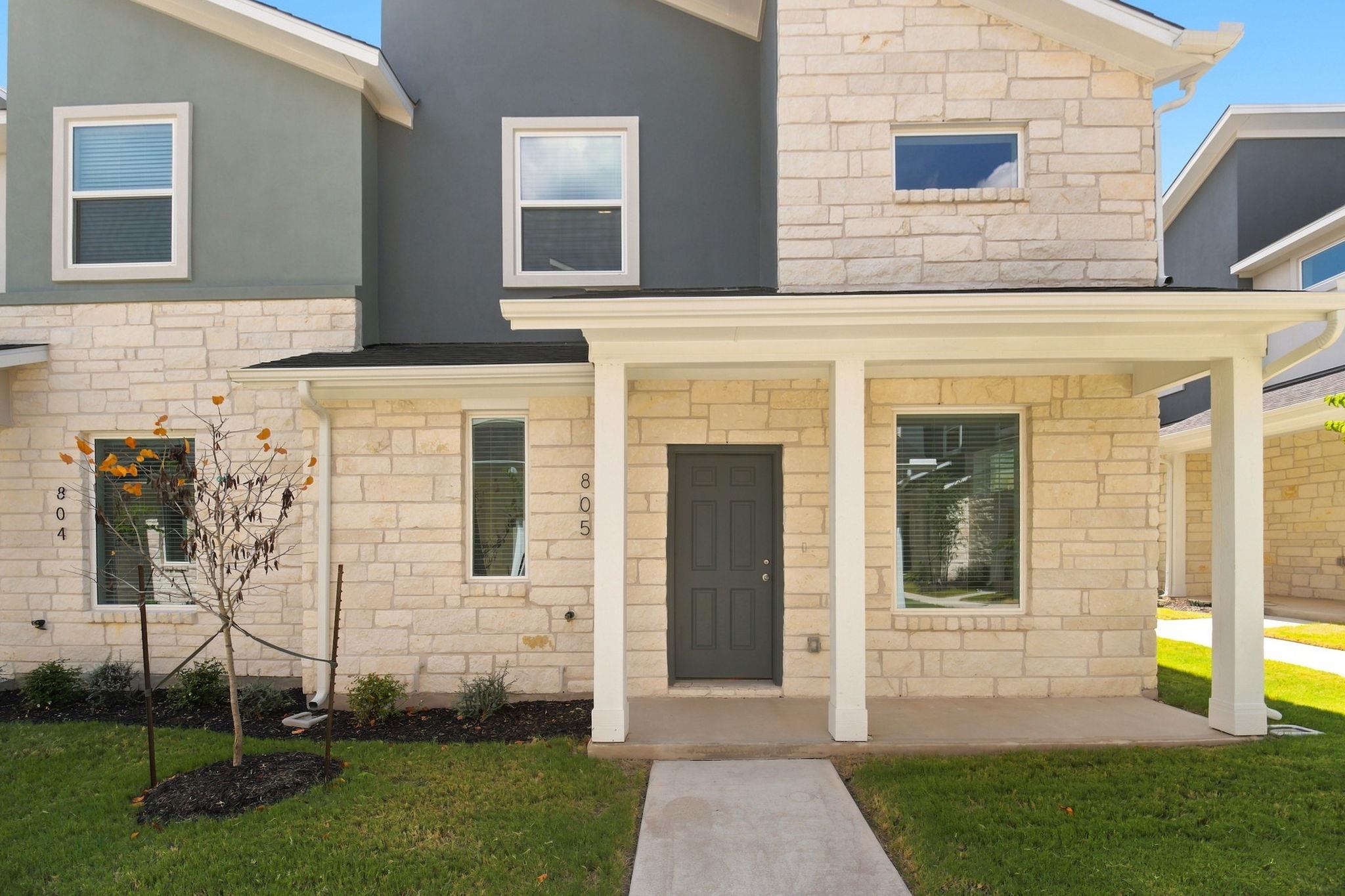 A welcoming front porch with white stone and stuc