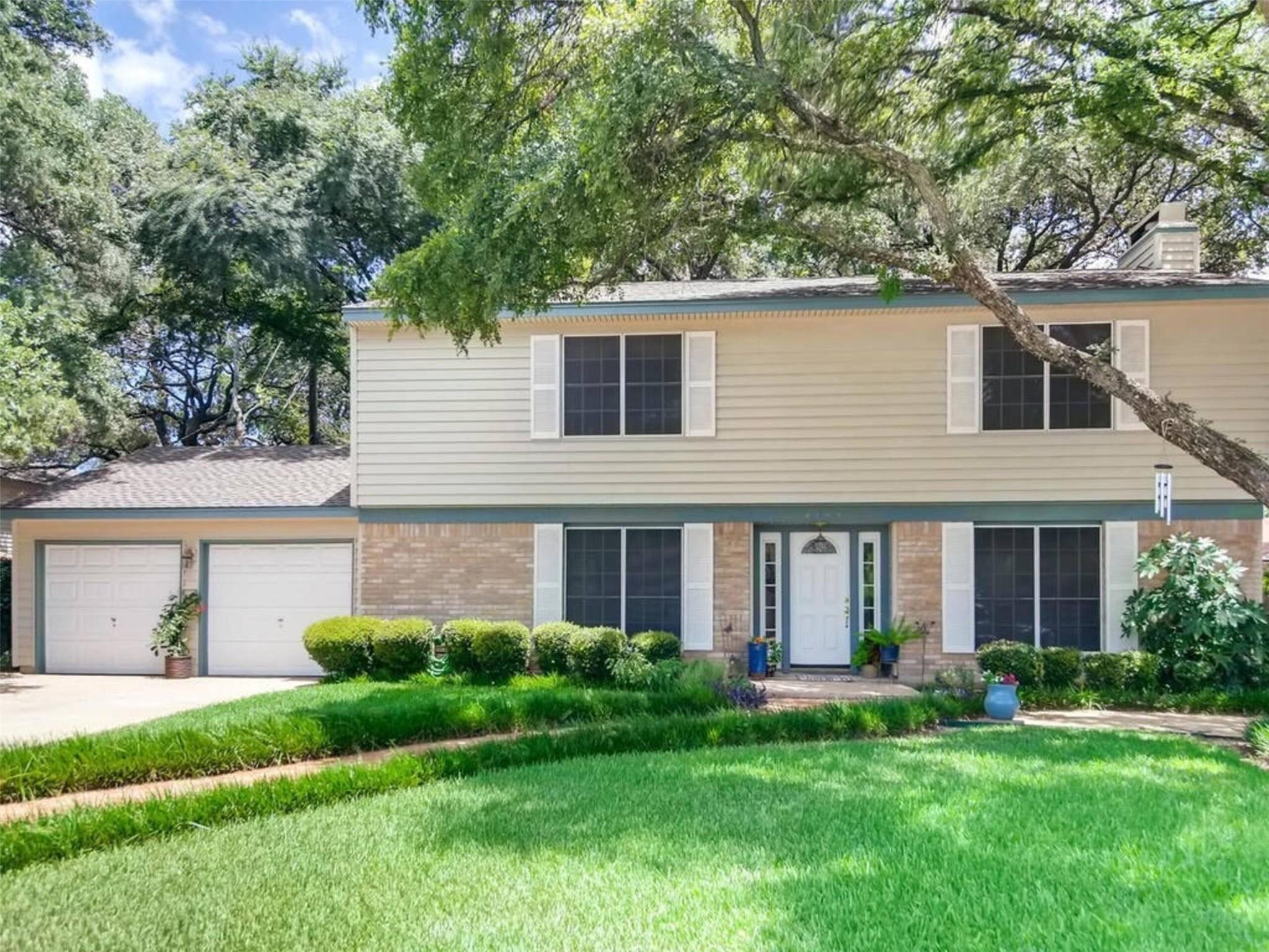 Mature trees shade a traditional two-story home w