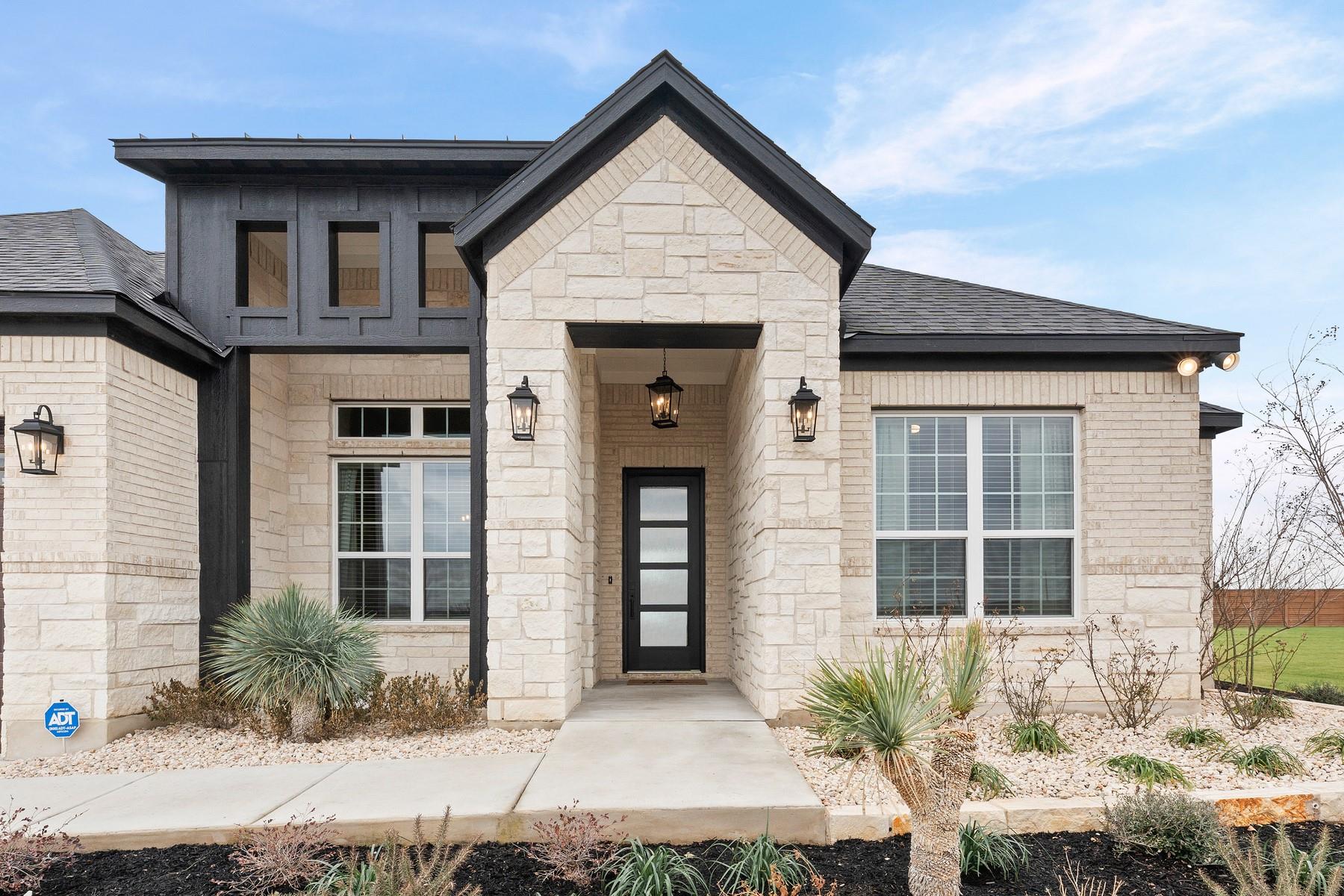 View of exterior entry with stone siding and roof