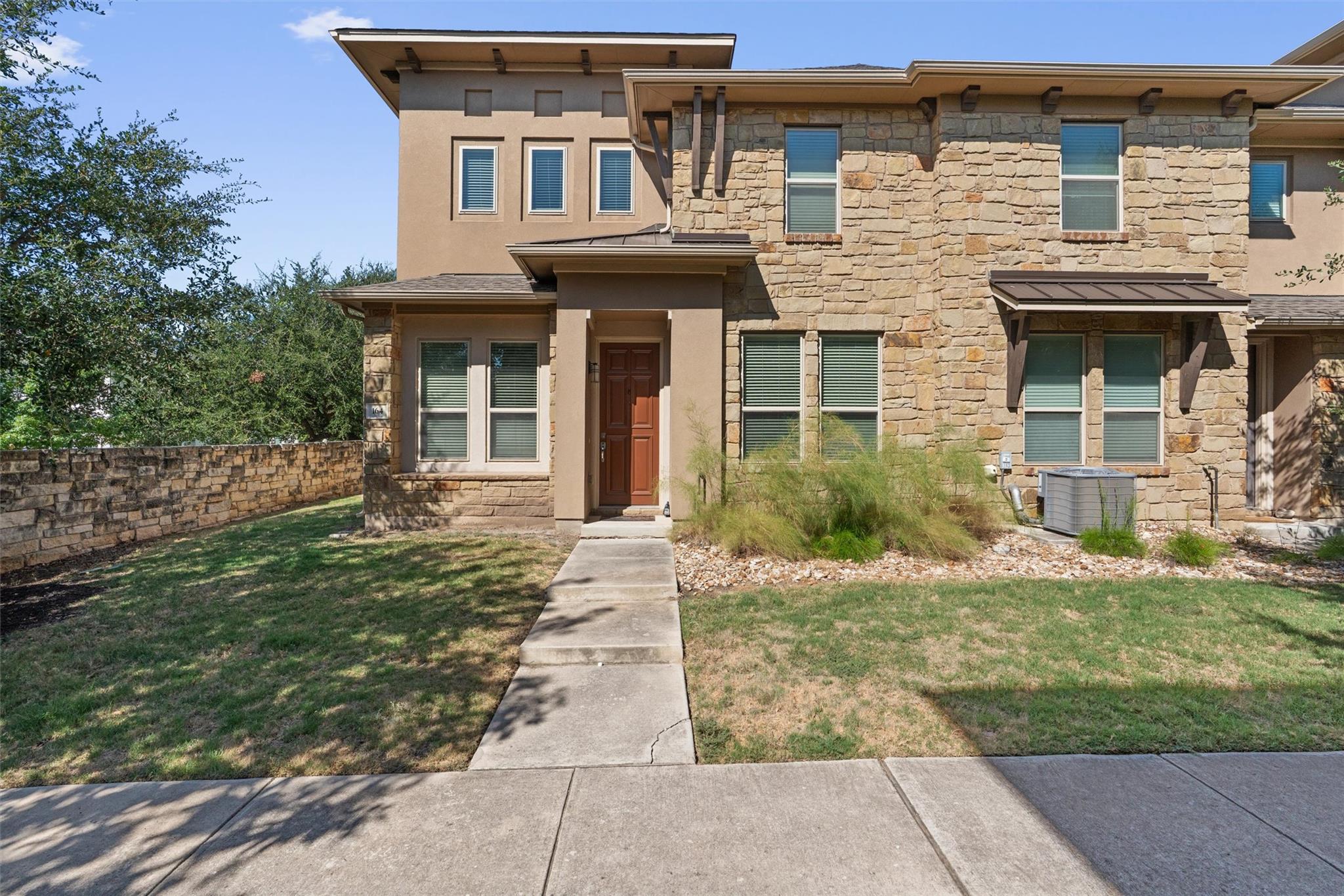 Textured stone veneer and neat stucco accents def