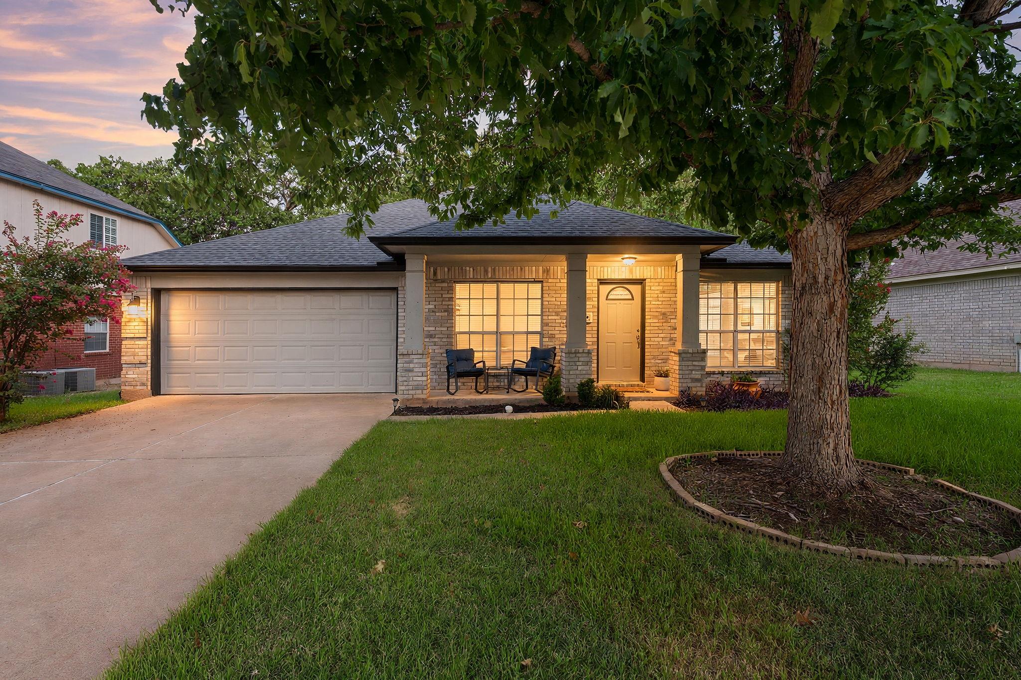Mature shade trees and a welcoming front porch fr