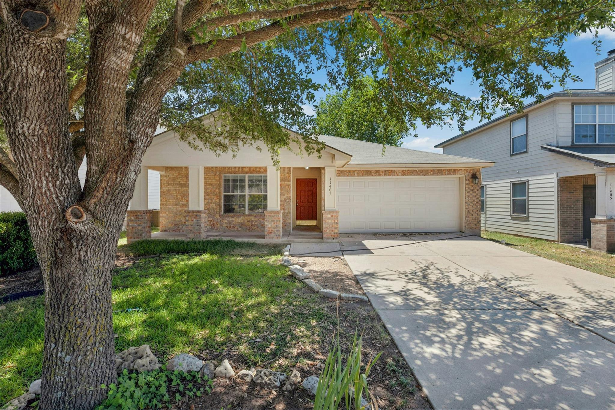 Mature shade trees frame a classic brick exterior
