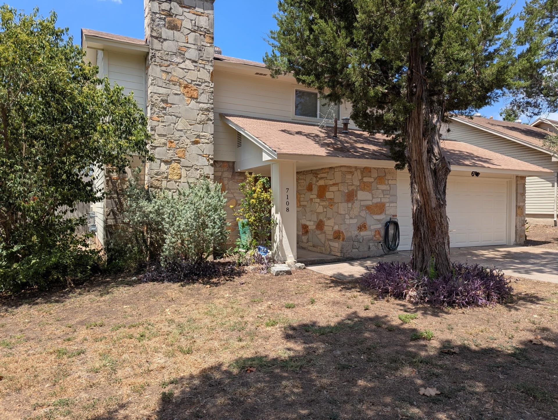 Natural stone accents and a soaring masonry chimn