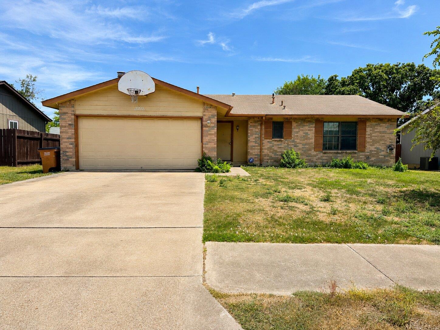 Classic brick accents and a spacious concrete dri