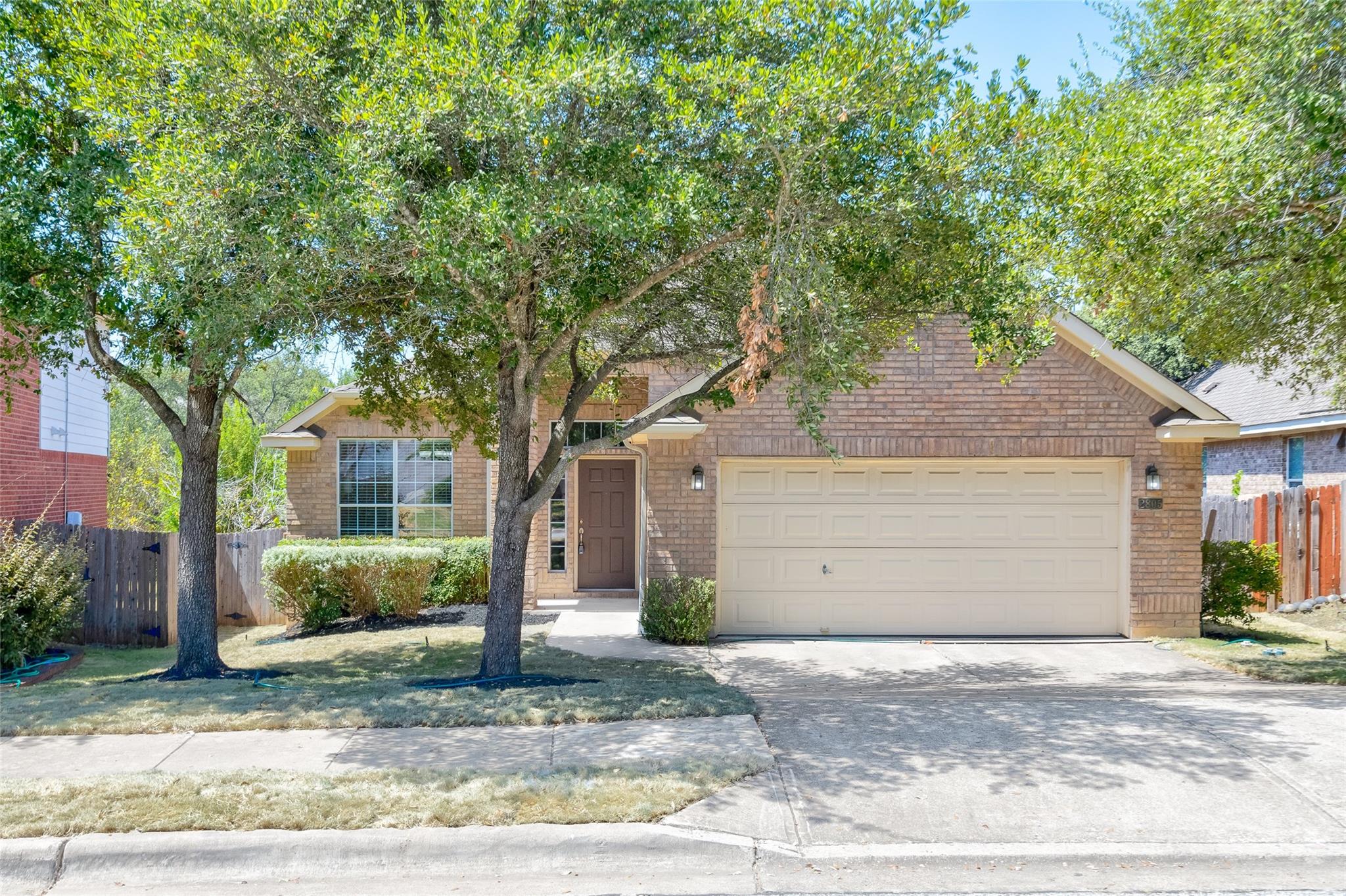 Mature trees shade a classic brick exterior featu
