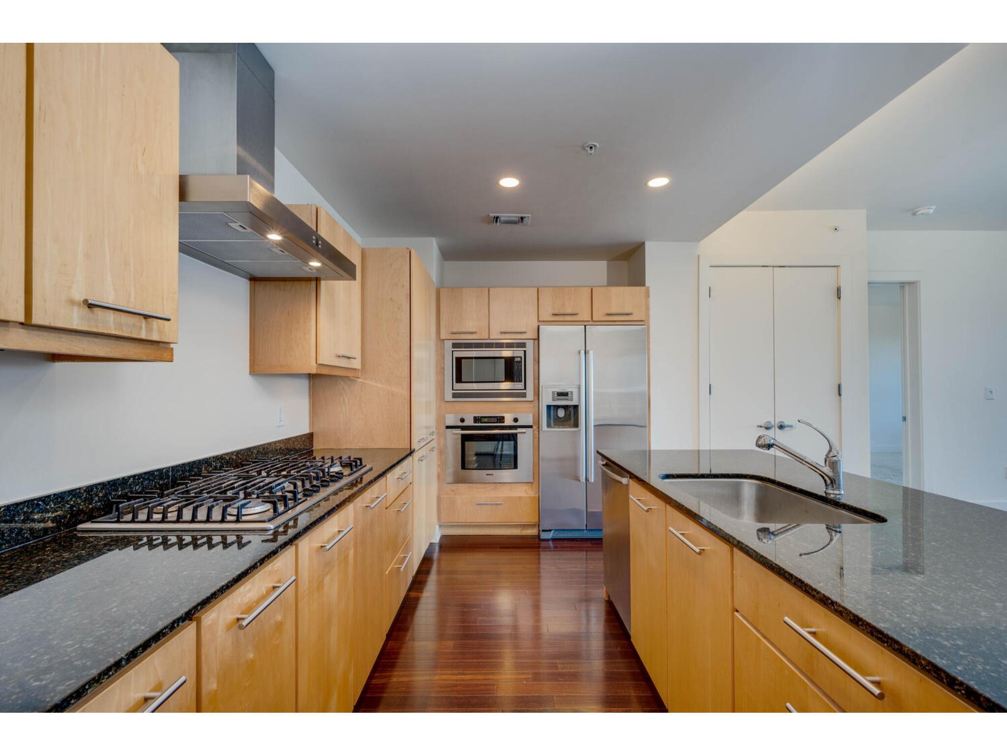 Rich wood flooring anchors this kitchen featuring
