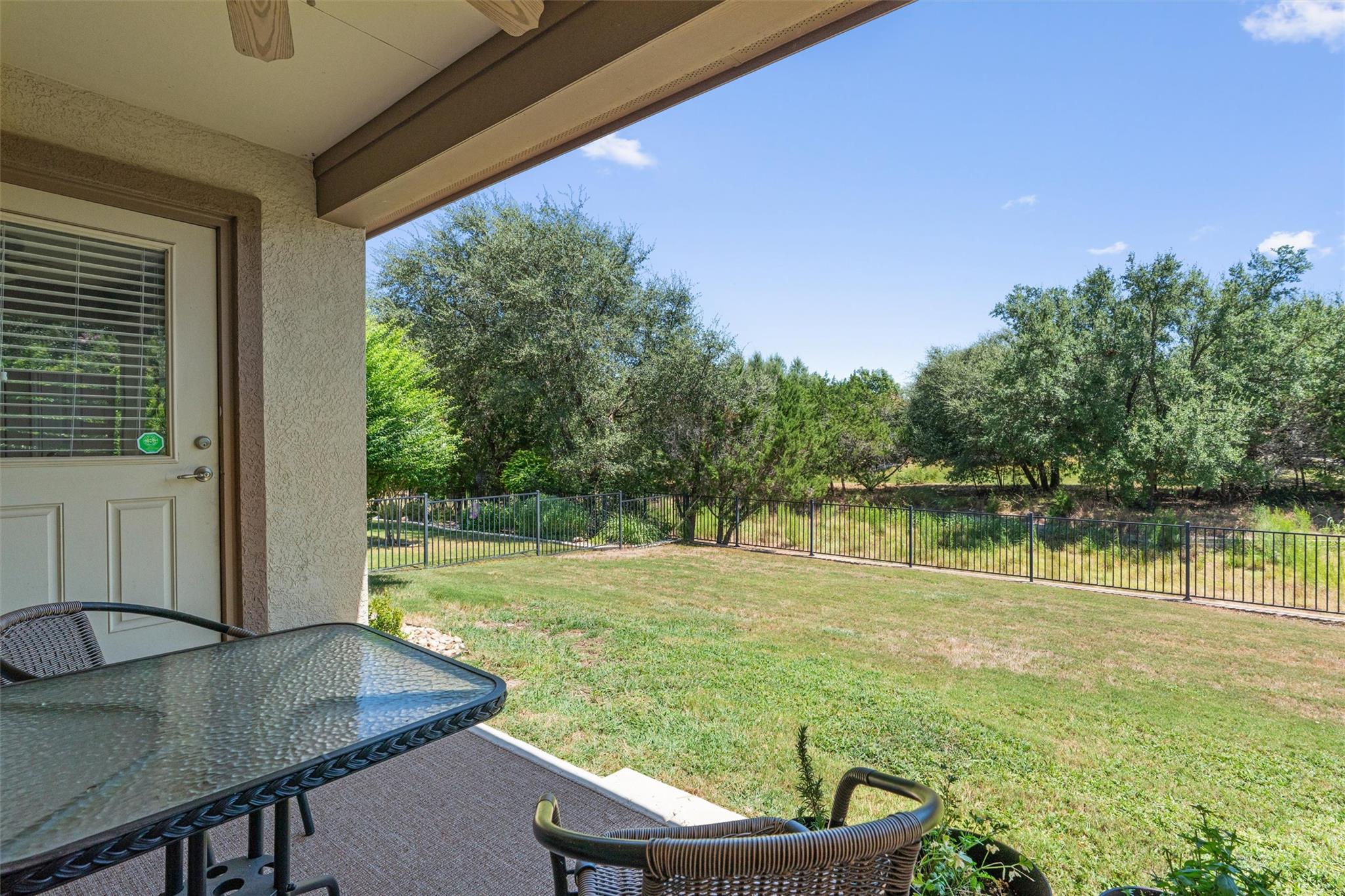 A sheltered patio opens directly to a grassy fenc