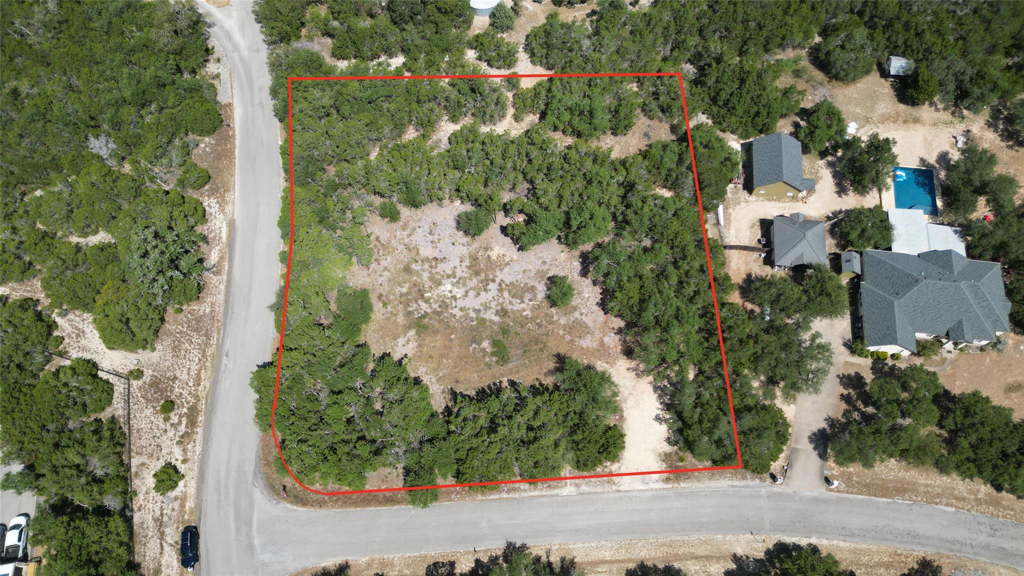 Mature trees frame a buildable home site bordered