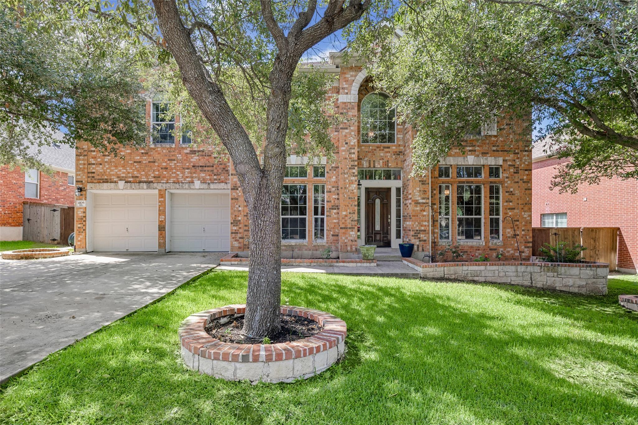 Mature trees shade a classic two-story brick exte