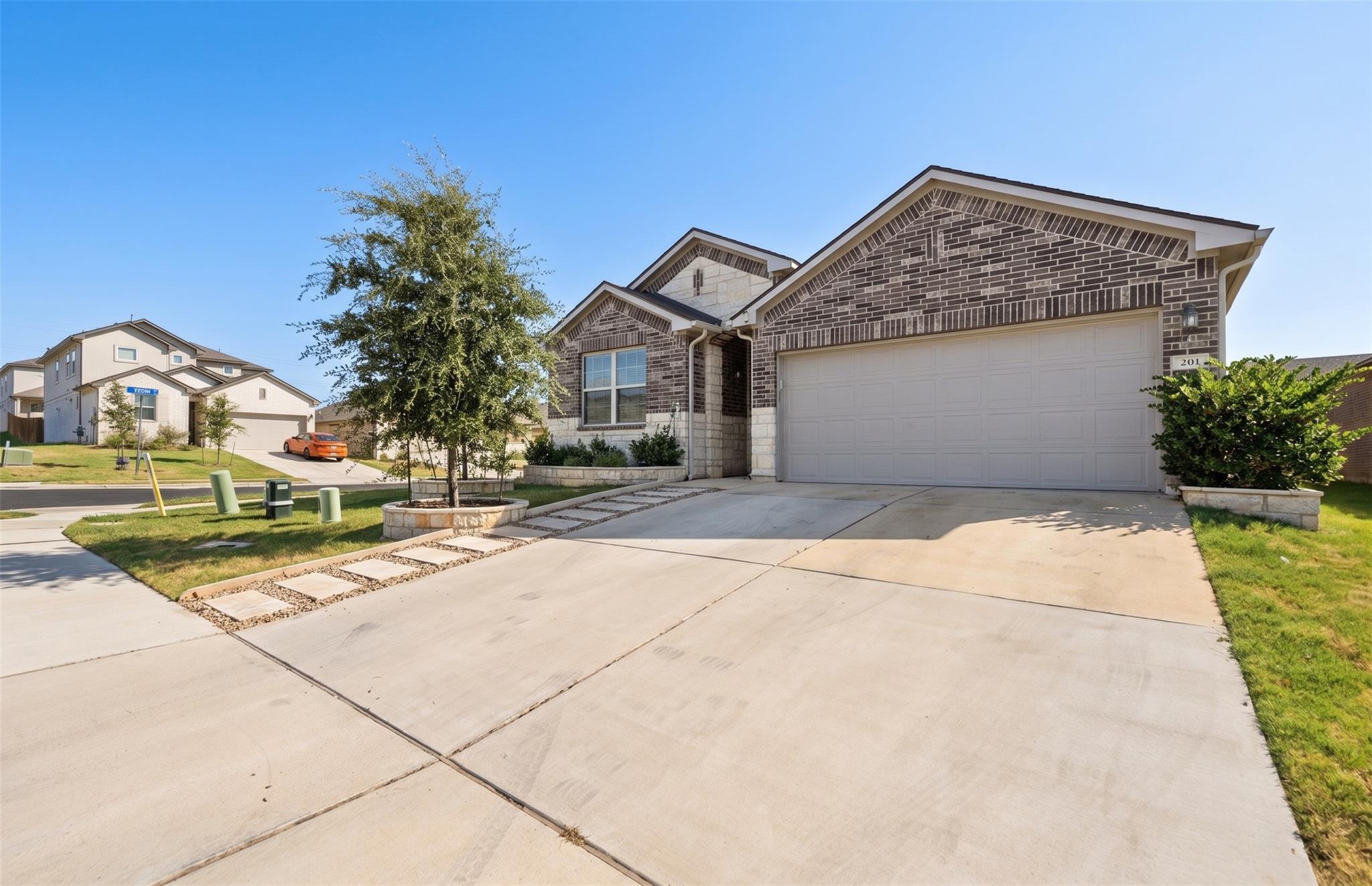 A wide concrete driveway leads to the two-car gar