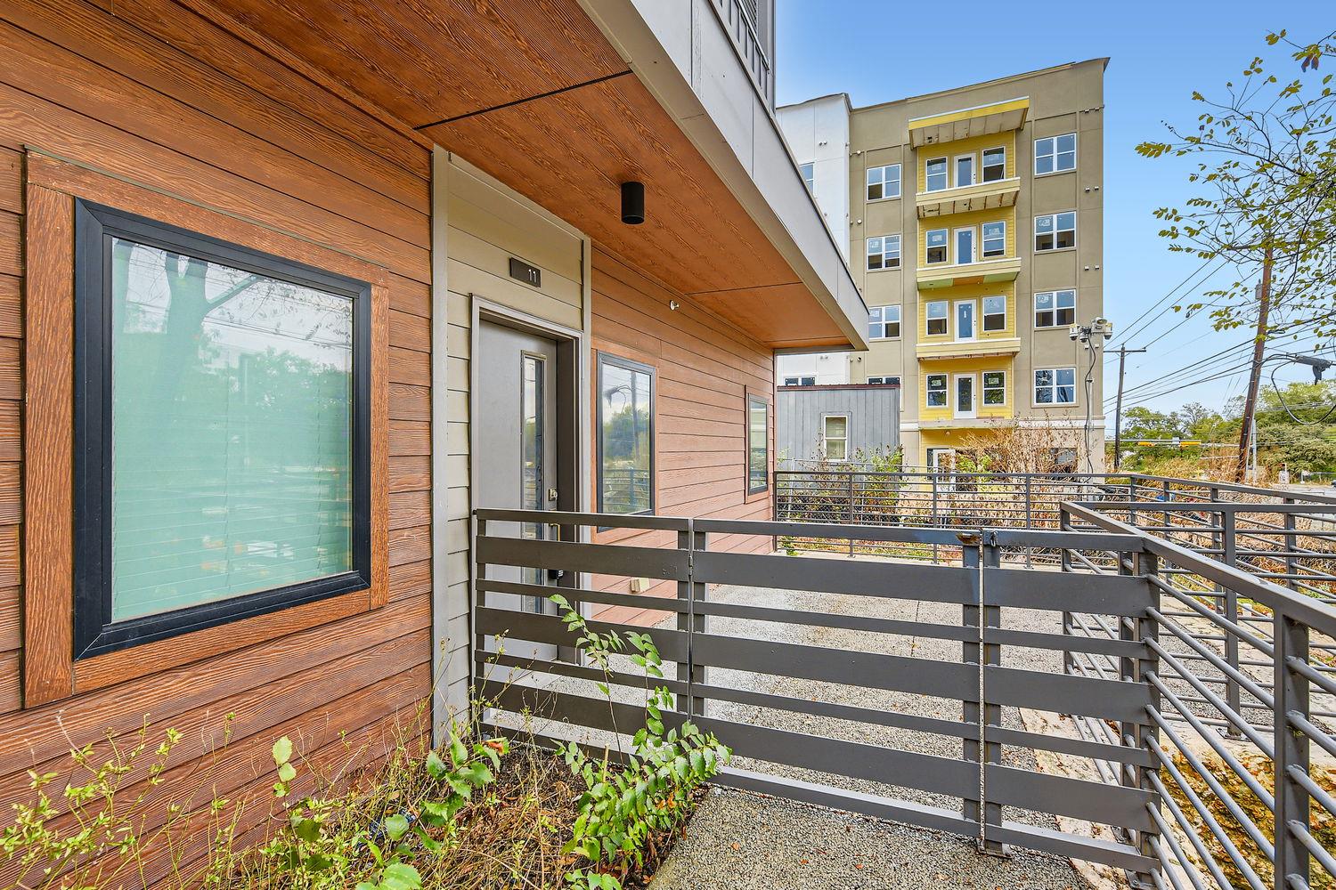 Warm wood siding and a private fenced entryway cr