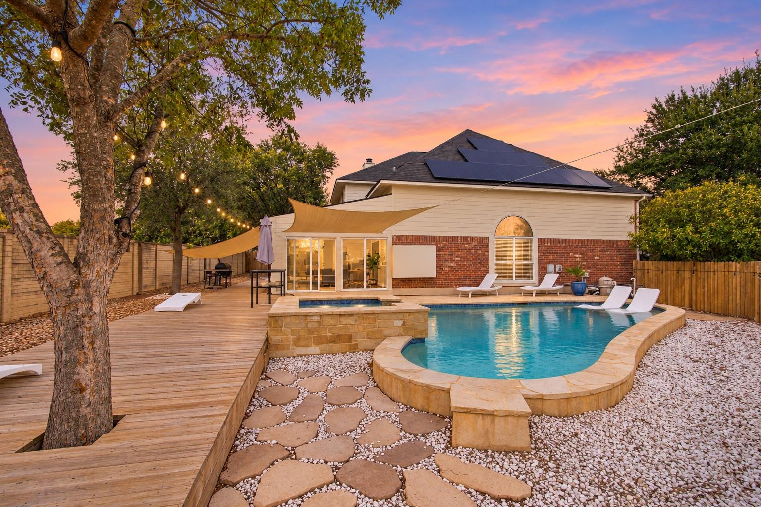A sparkling in-ground pool and spacious wooden de