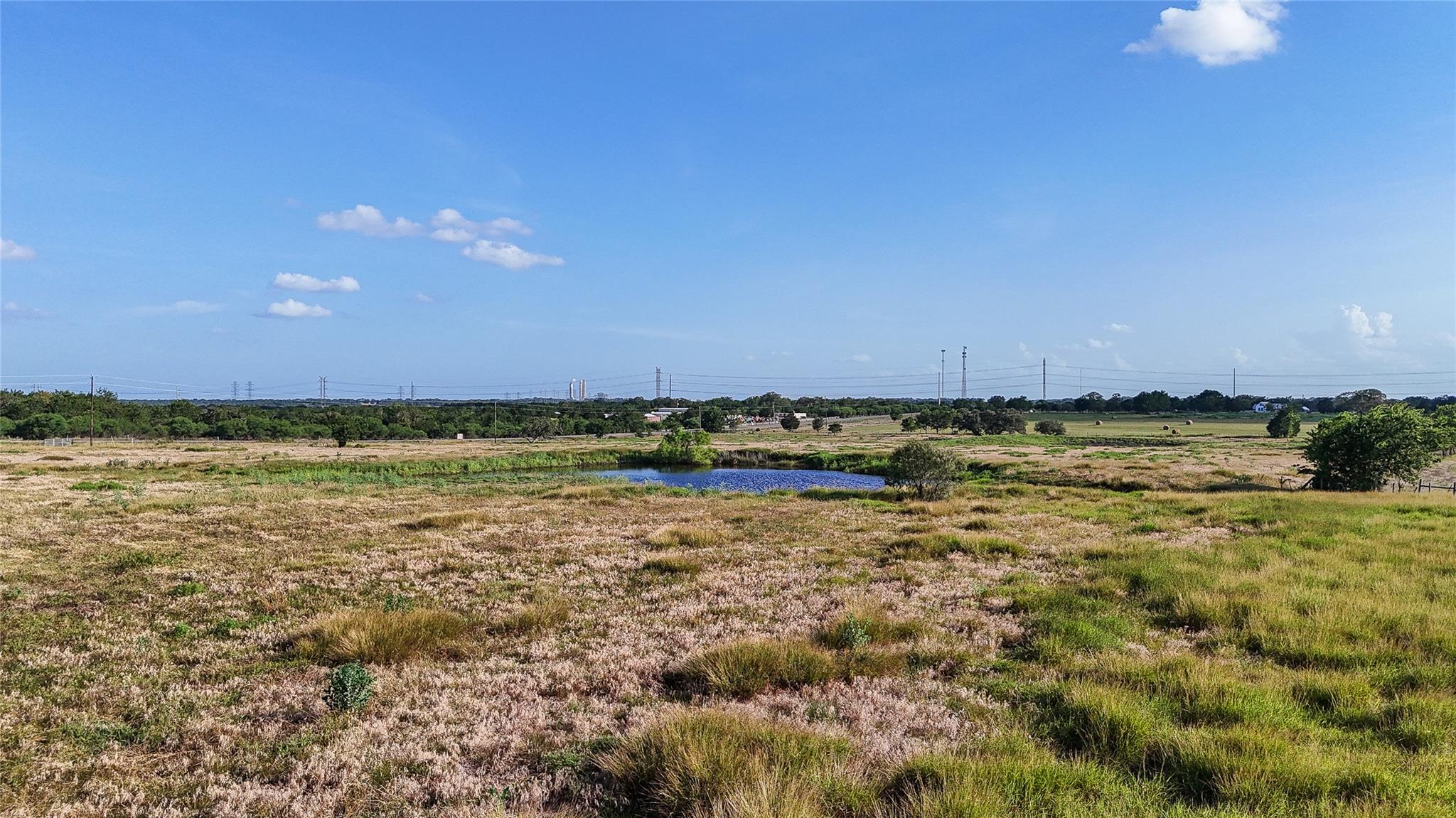Rolling grassy fields frame a scenic private pond