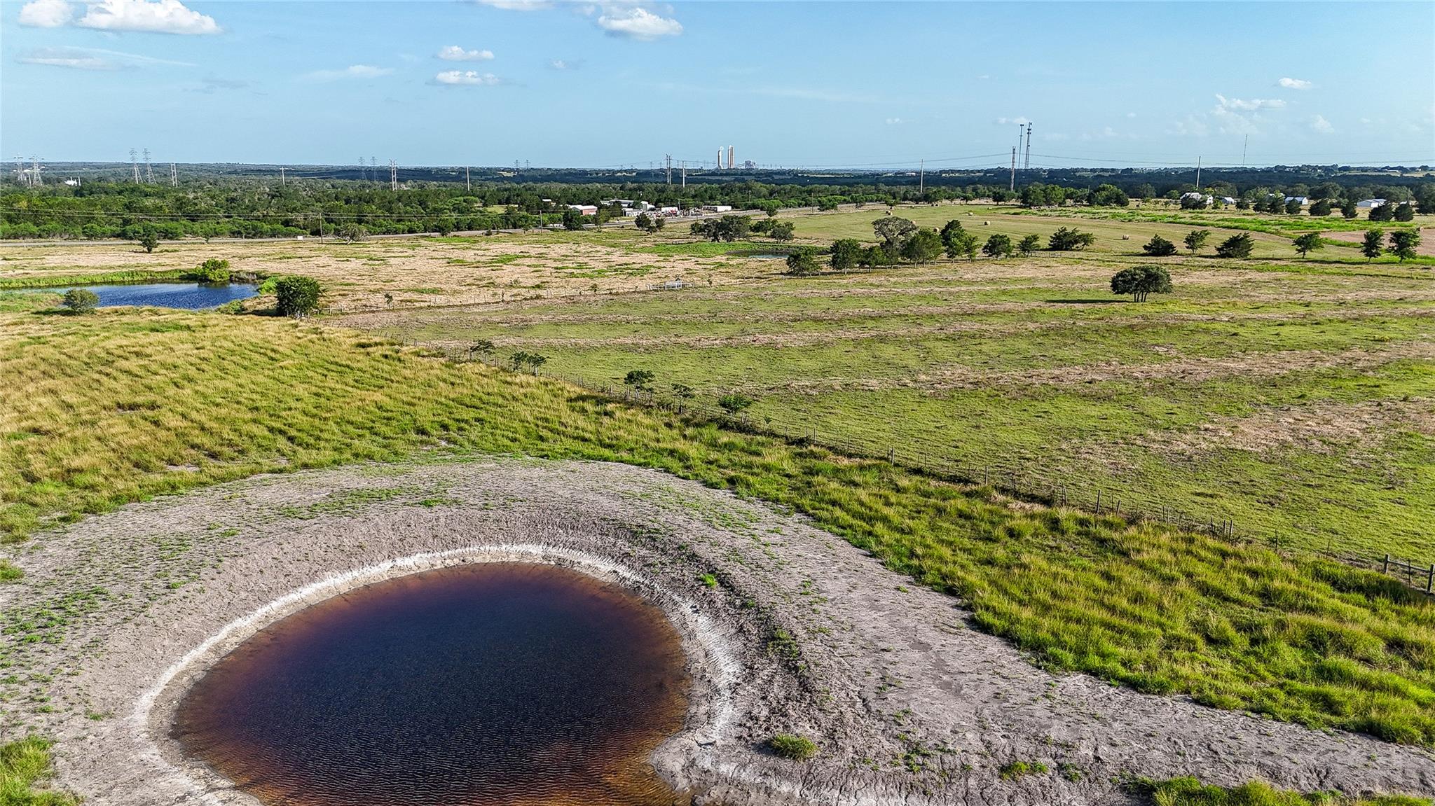 Rolling green pastures and quiet stock ponds defi