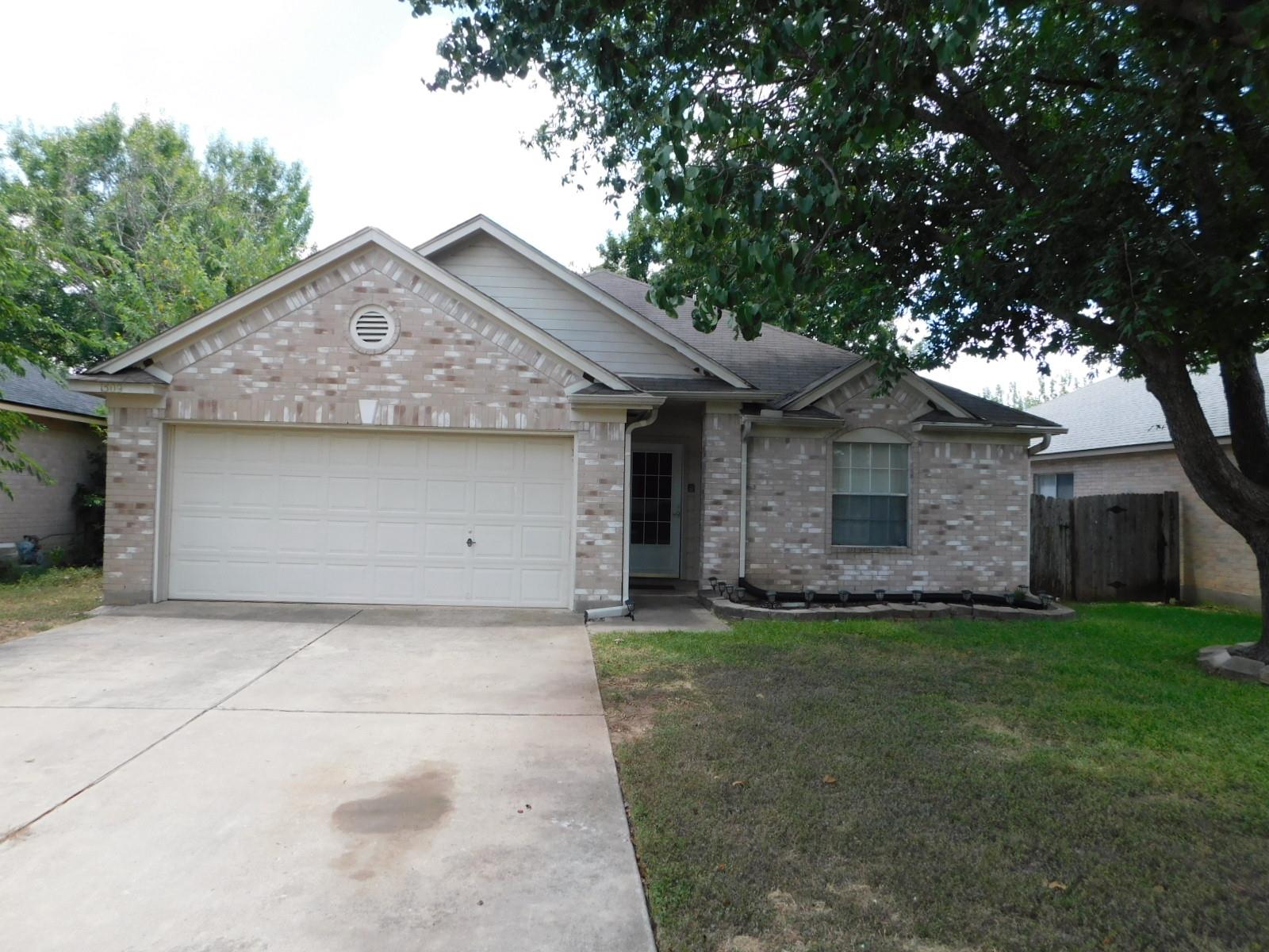 A classic brick exterior and concrete driveway le
