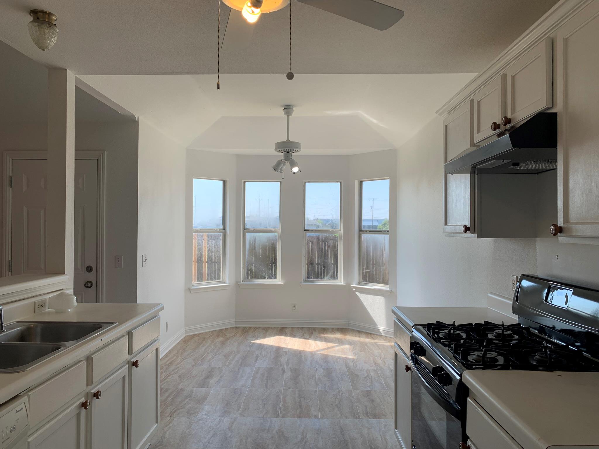 Hardwood floors and a sunlit bay window alcove de