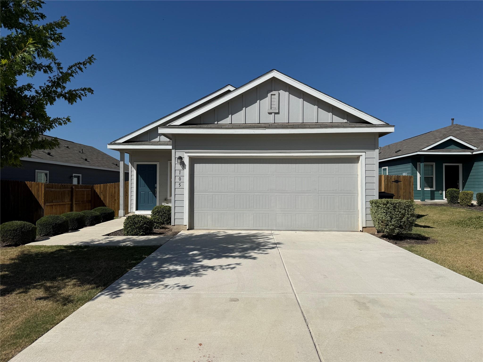 A concrete driveway leads to the front-facing gar