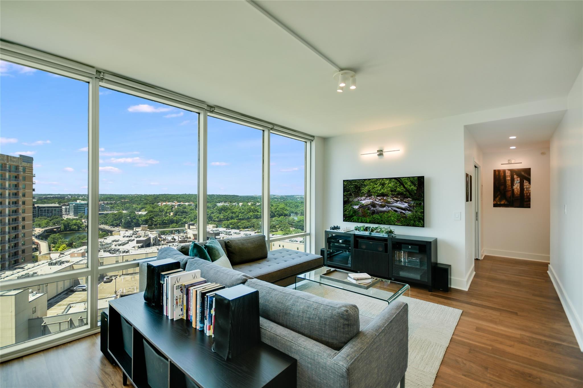Floor-to-ceiling windows flood this modern living