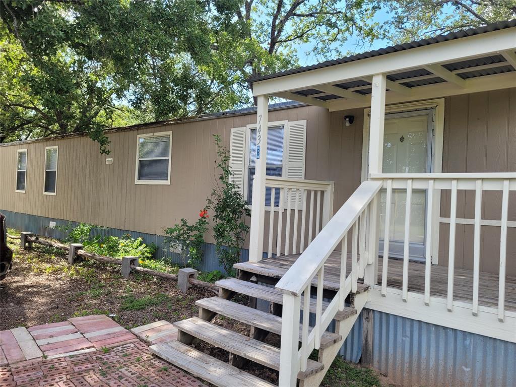 Wooden steps ascend to a covered front porch welc