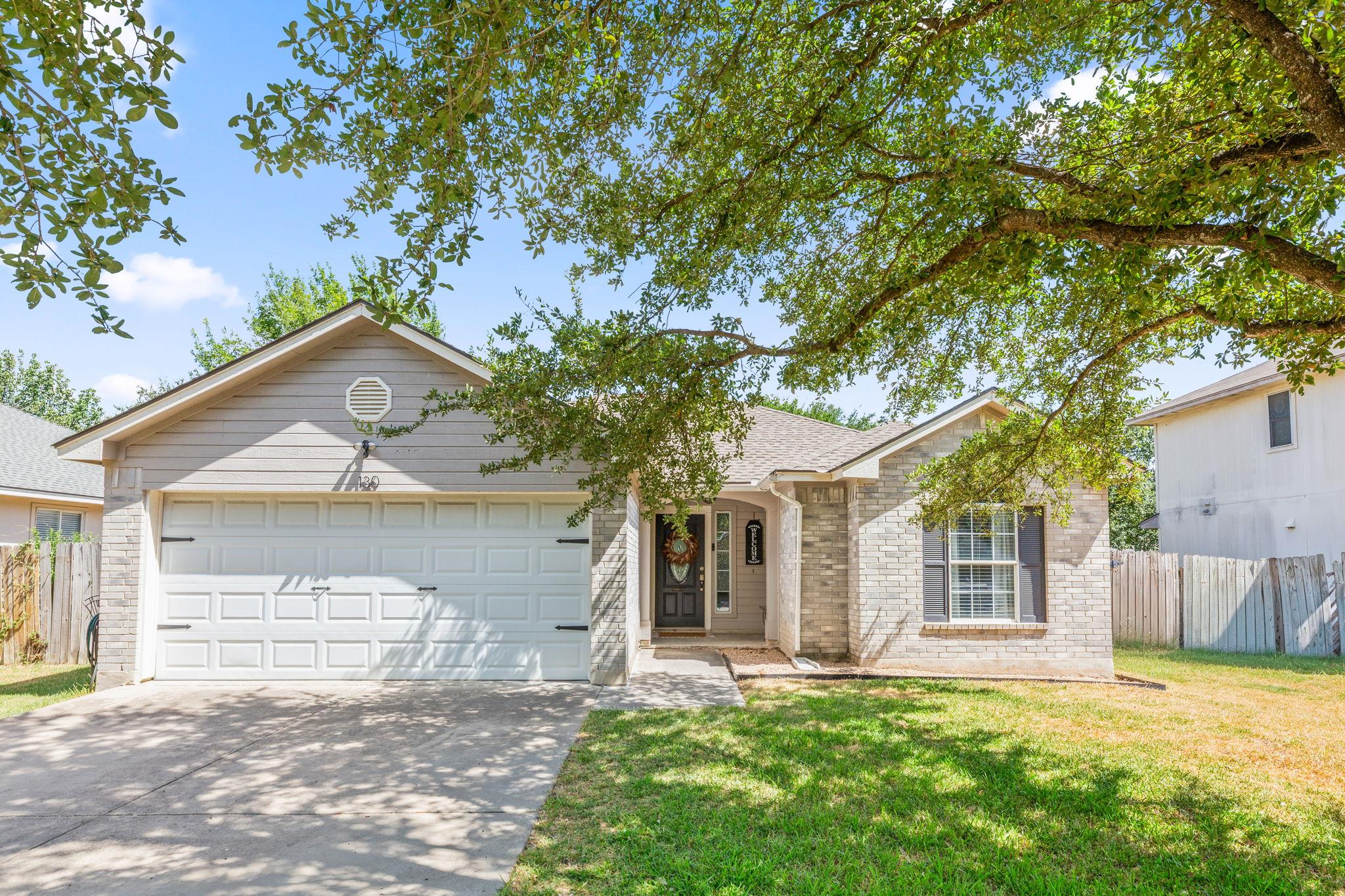 Mature shade trees frame a classic single-story b