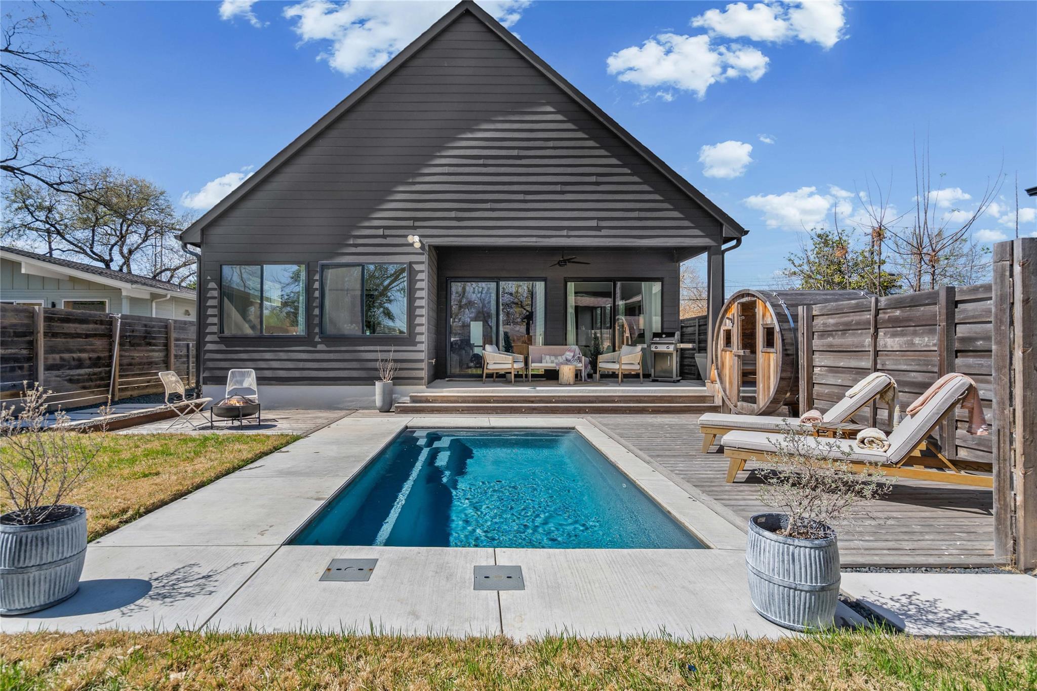 An inviting backyard oasis showcases a sleek swim