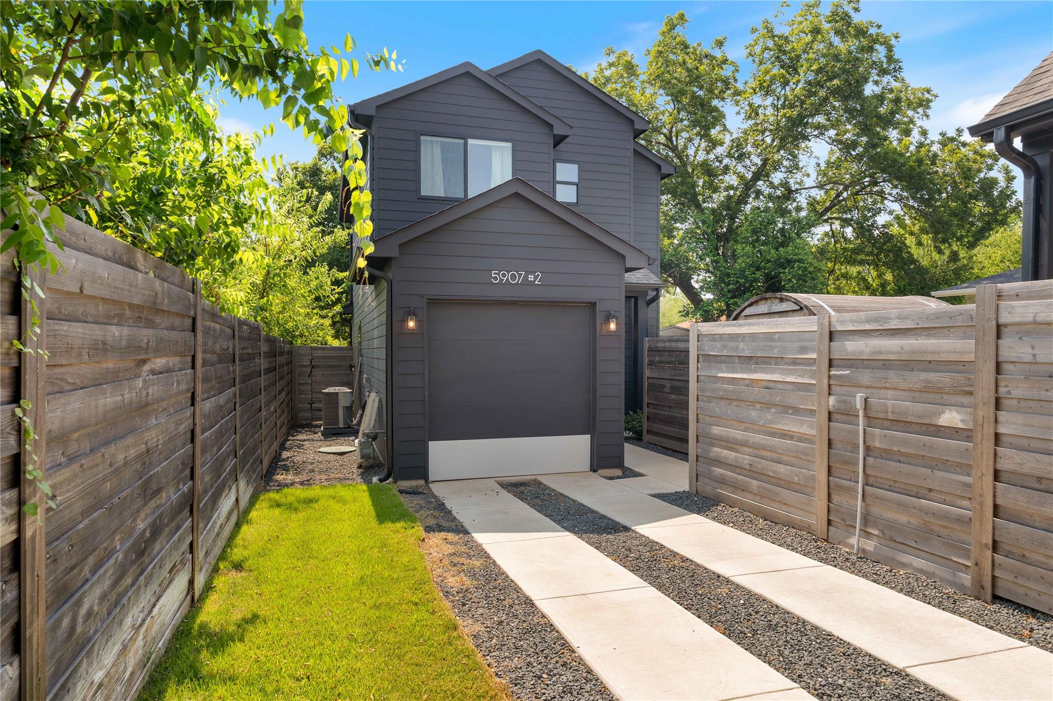A modern two-story exterior showcases sleek dark 