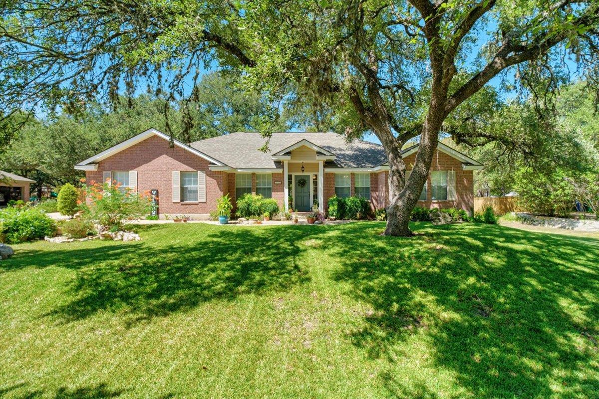 Established oak trees shade a classic brick facad