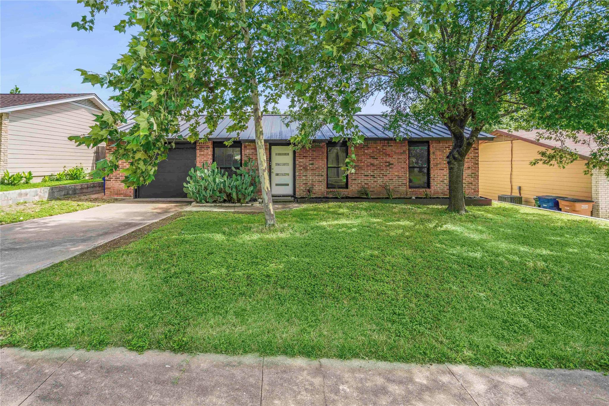 Mature shade trees frame a classic brick exterior