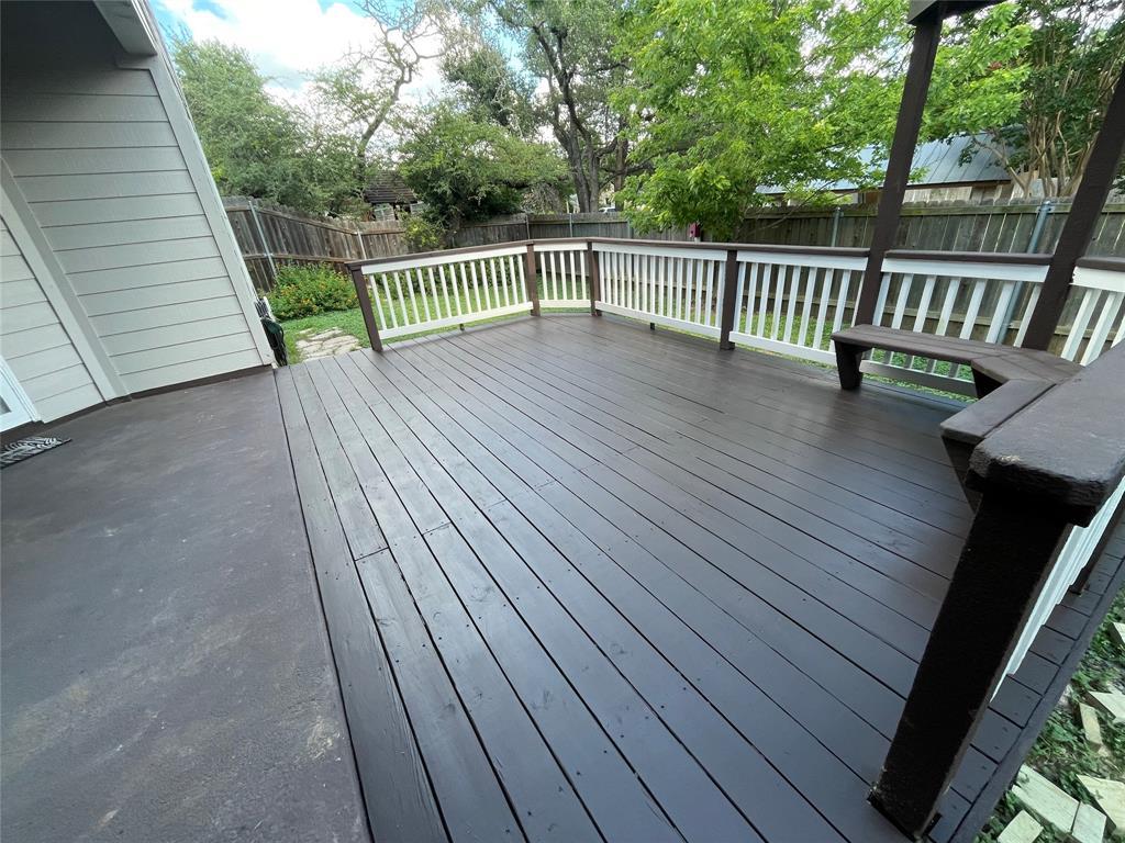 An elevated wood deck with perimeter railing over