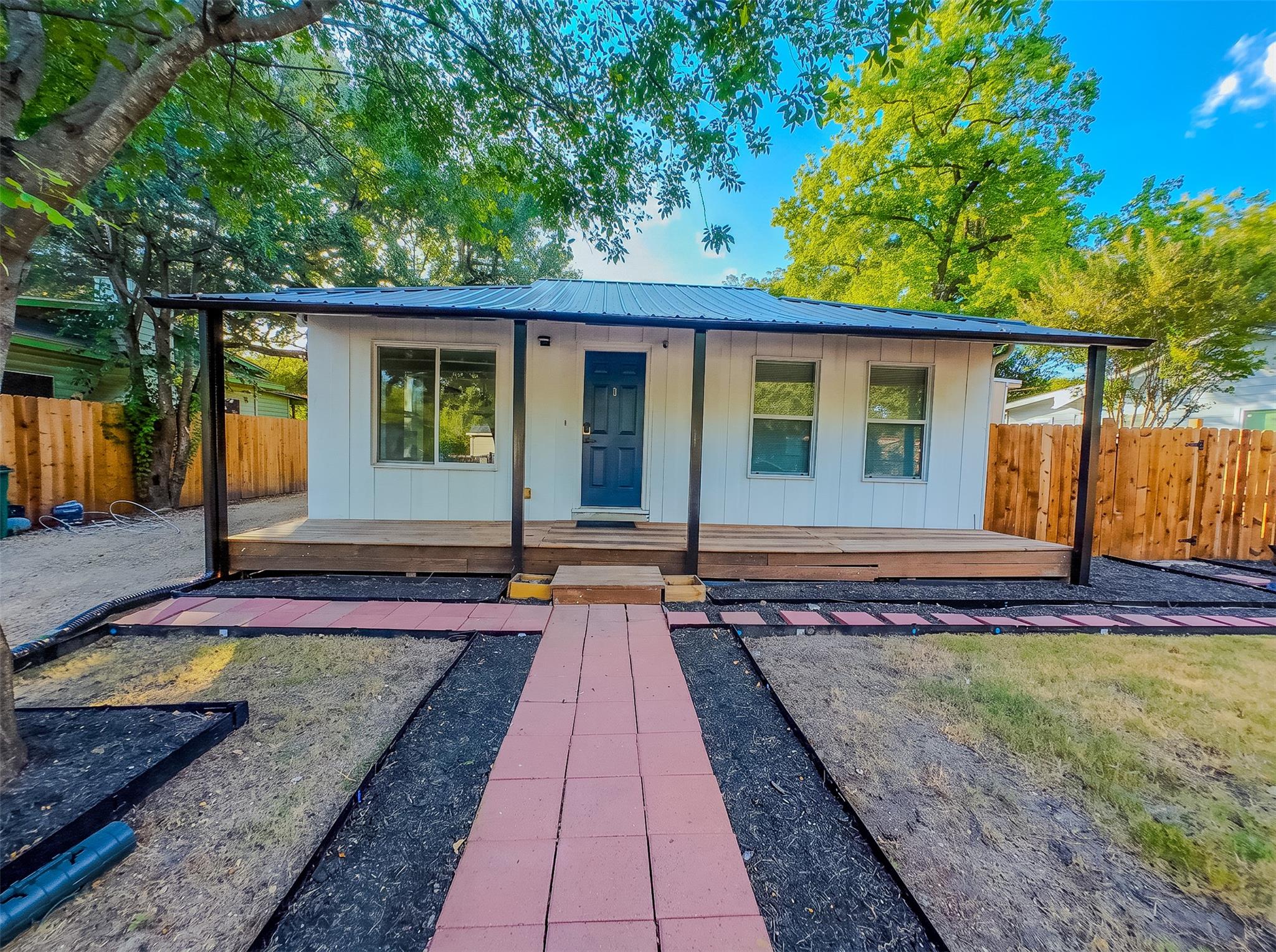 A straight paved walkway leads up to the covered 