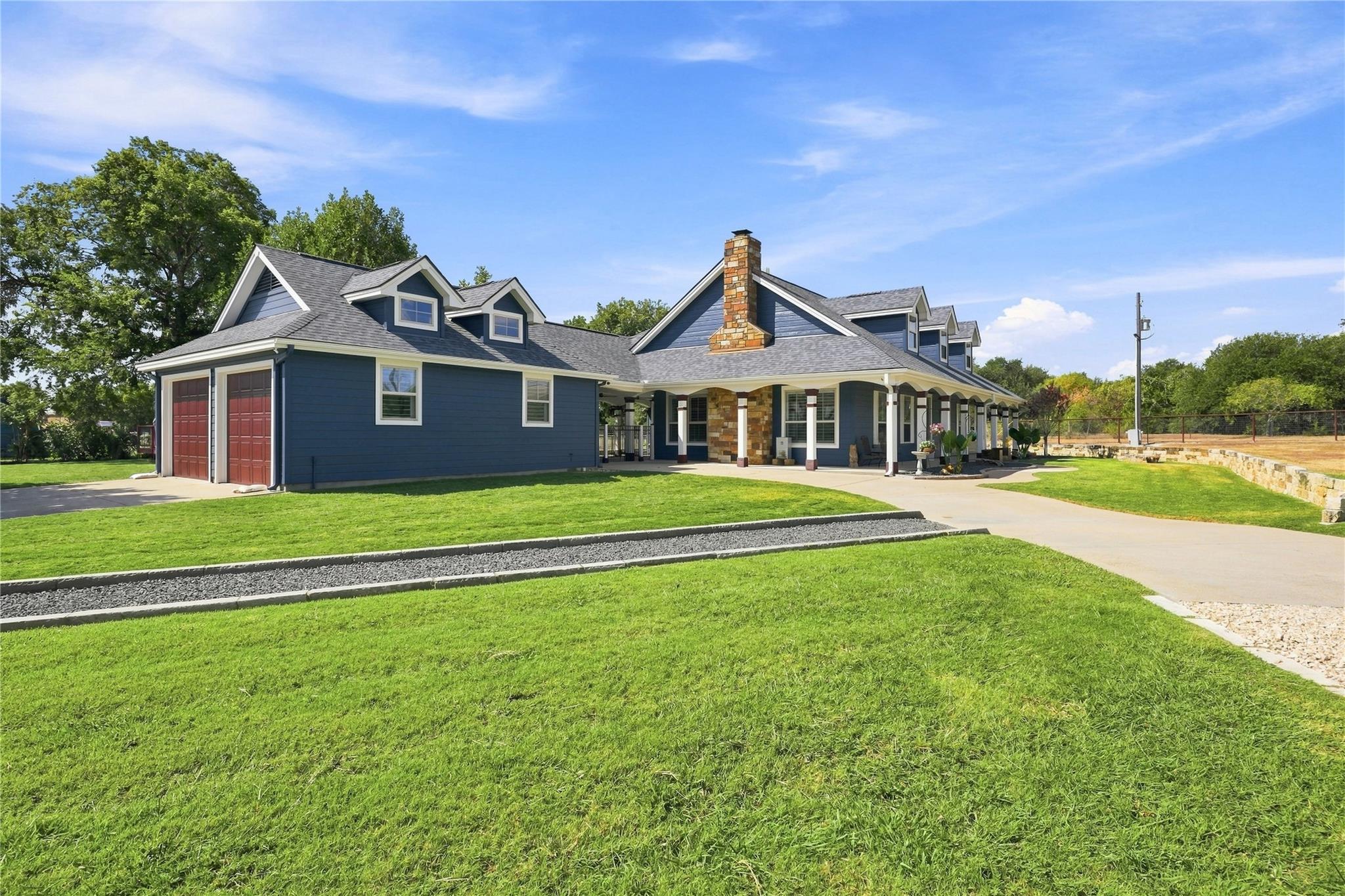 A spacious concrete driveway winds past manicured