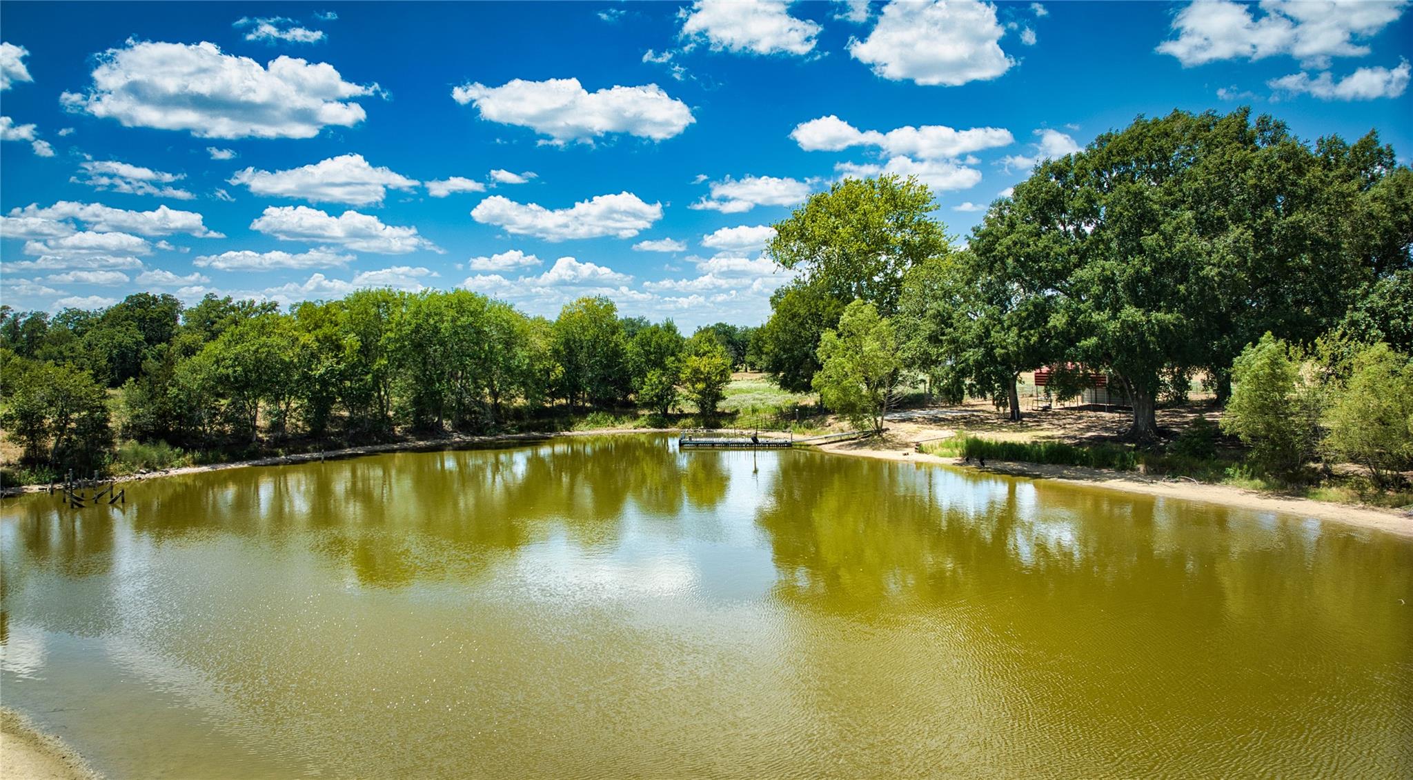 Mature trees line the quiet banks of a private st