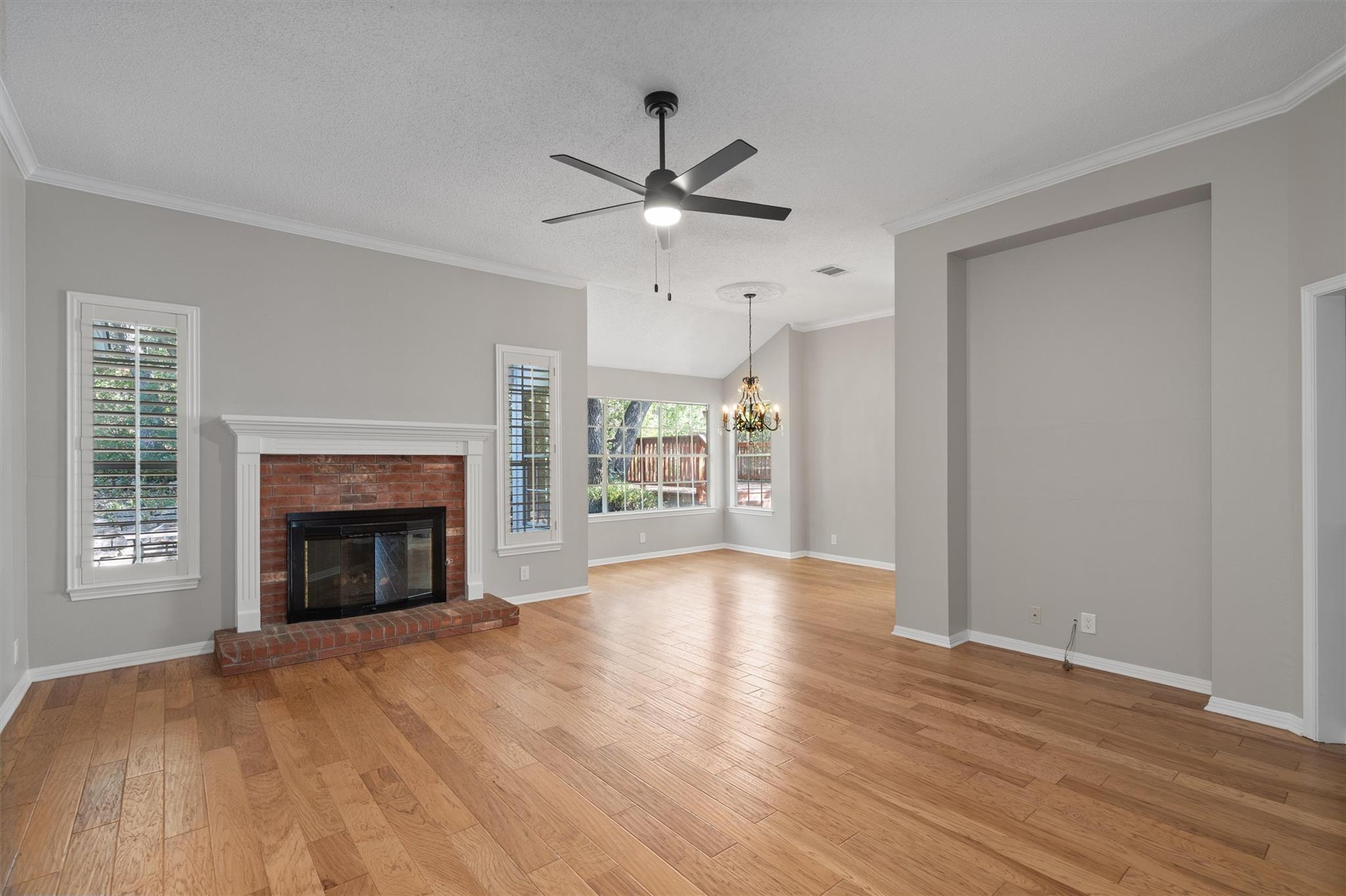 Rich hardwood floors and a classic brick fireplac