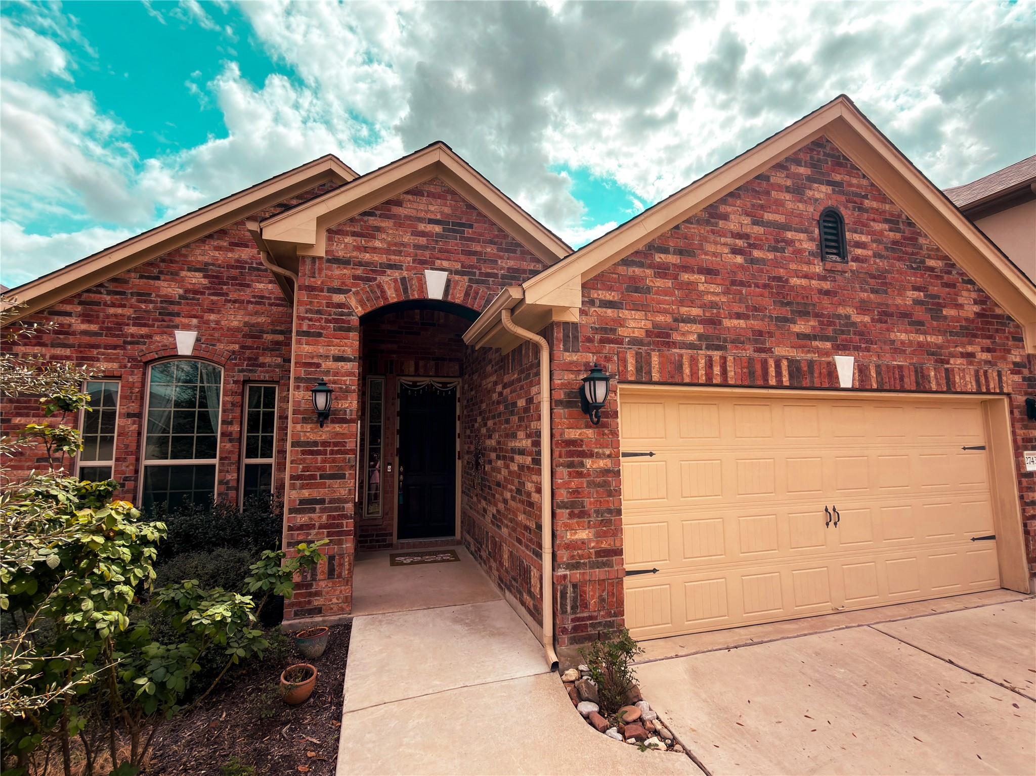 View of front of house with brick siding, a garag