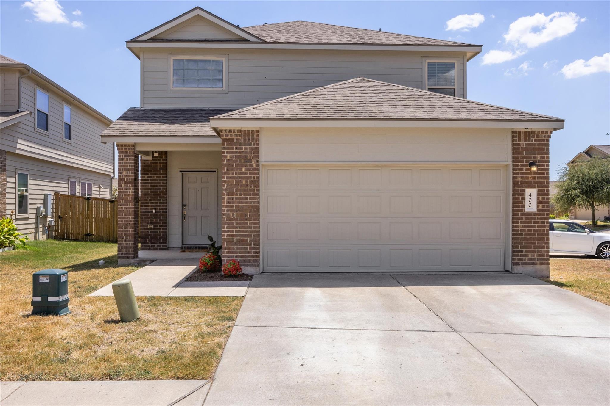 Brick accents and a spacious concrete driveway de