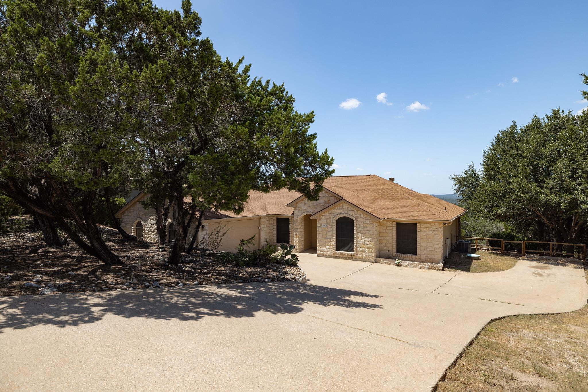 Stone masonry walls and an expansive driveway fra