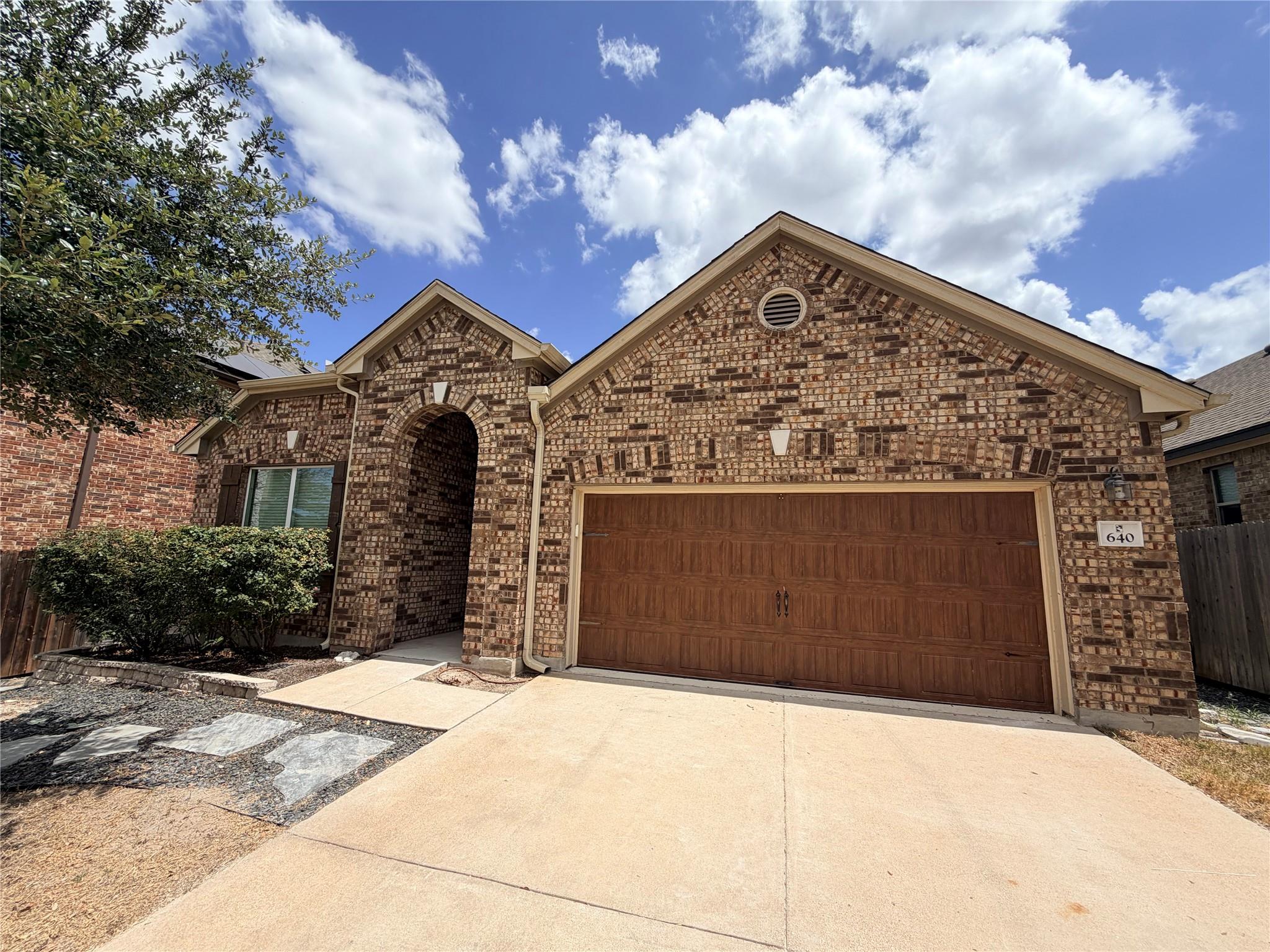 A classic brick exterior and a concrete driveway 