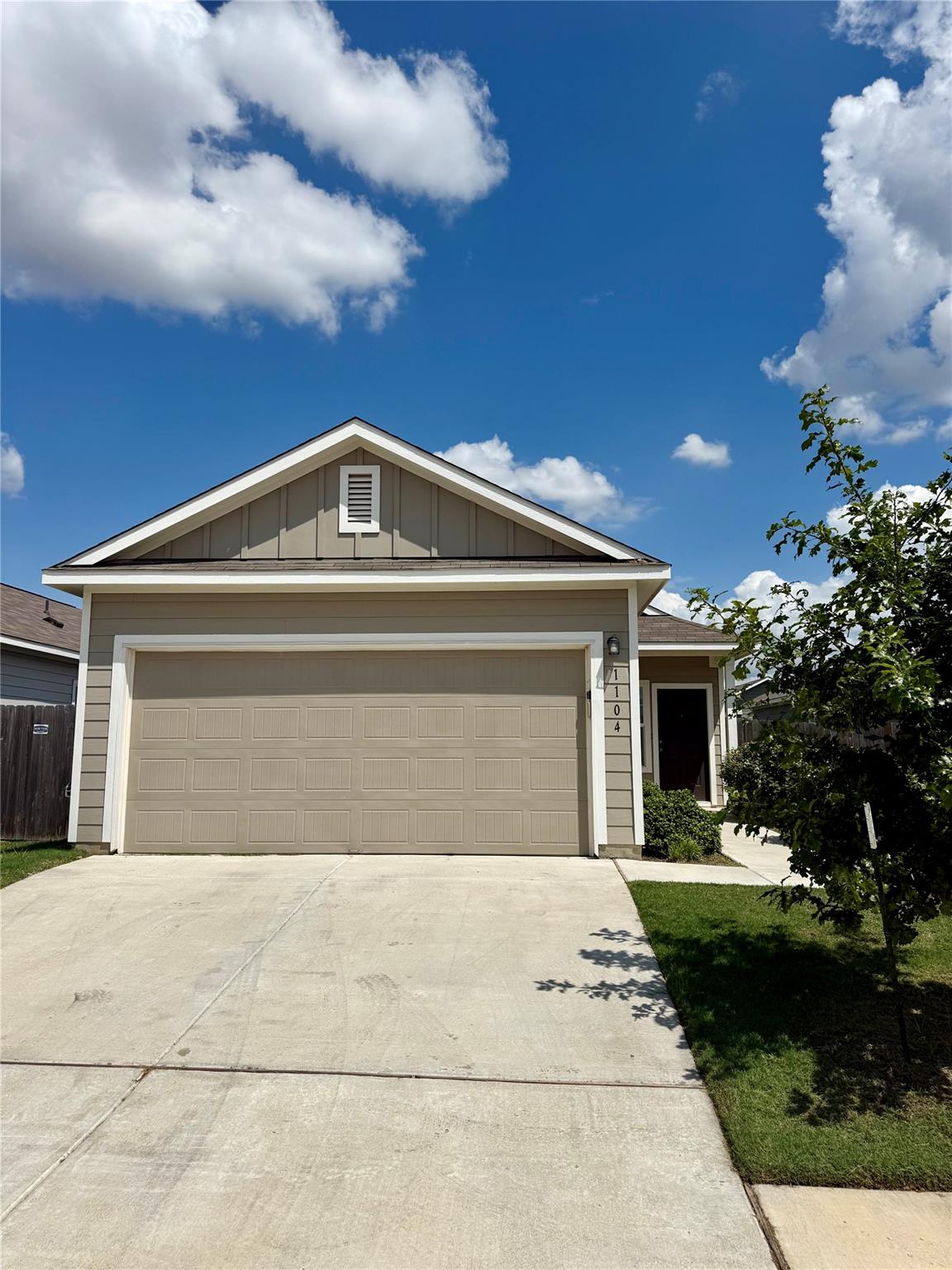 A wide concrete driveway leads to the attached ga