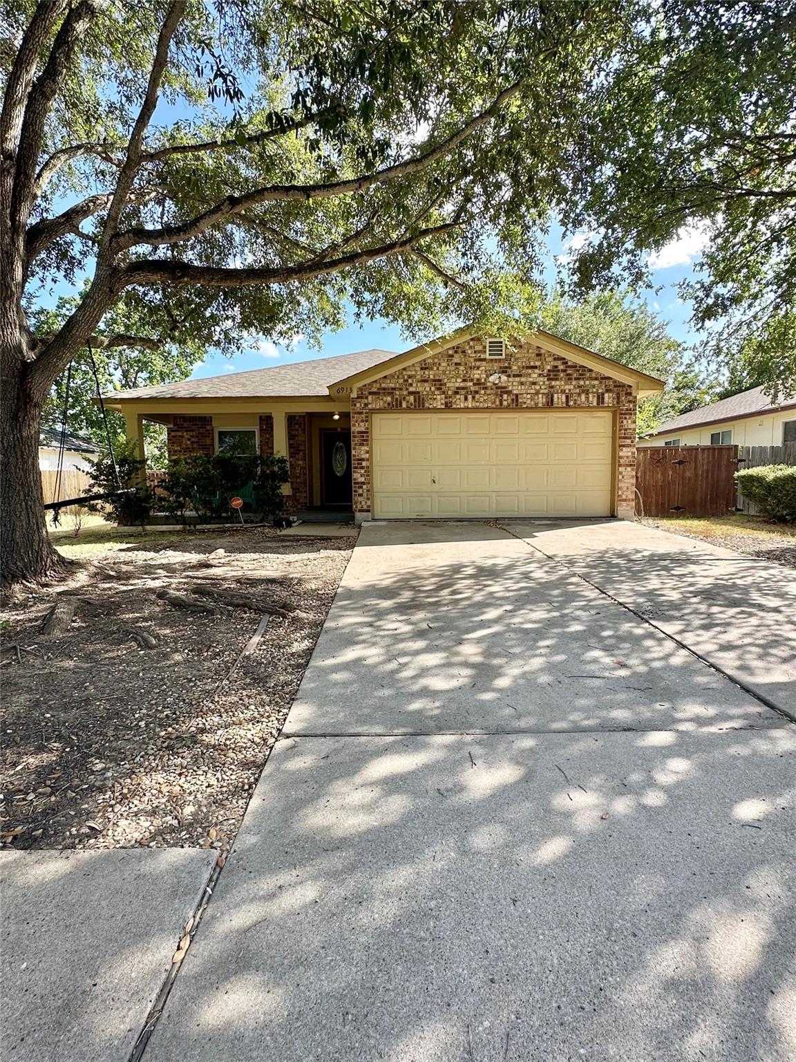 Mature trees shade a classic brick exterior compl