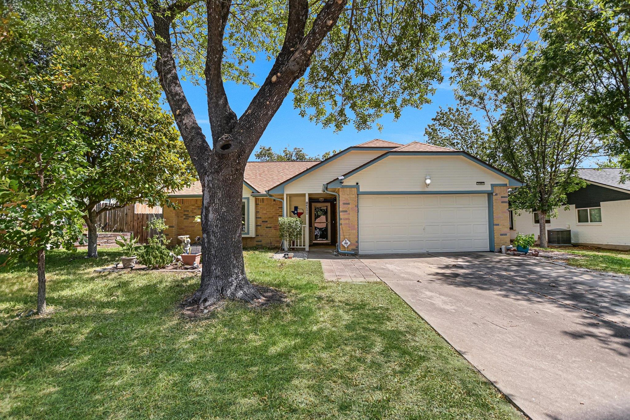 Mature shade trees frame the welcoming entrance a