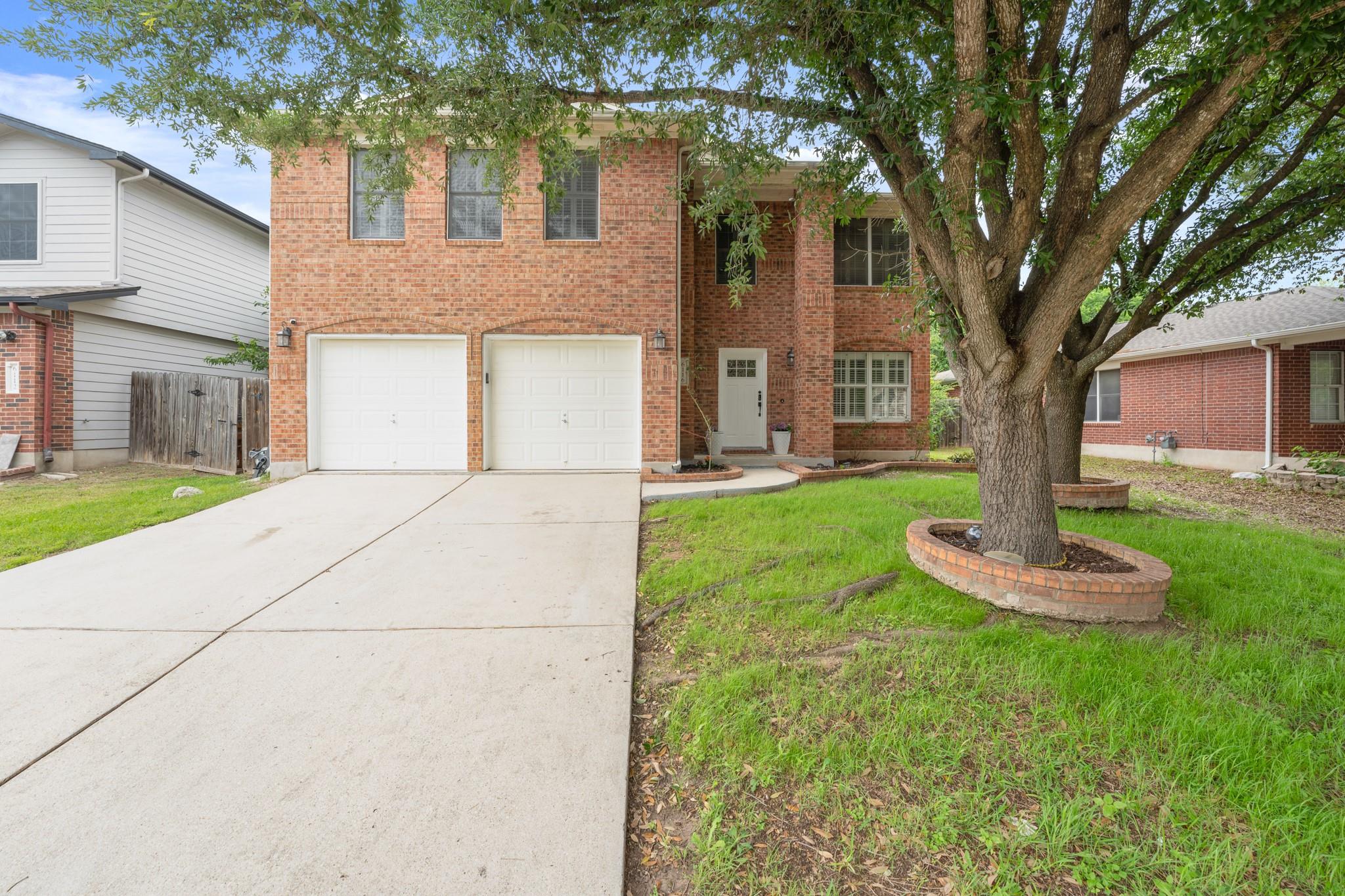 Two-story brick exterior featuring a two-car gara